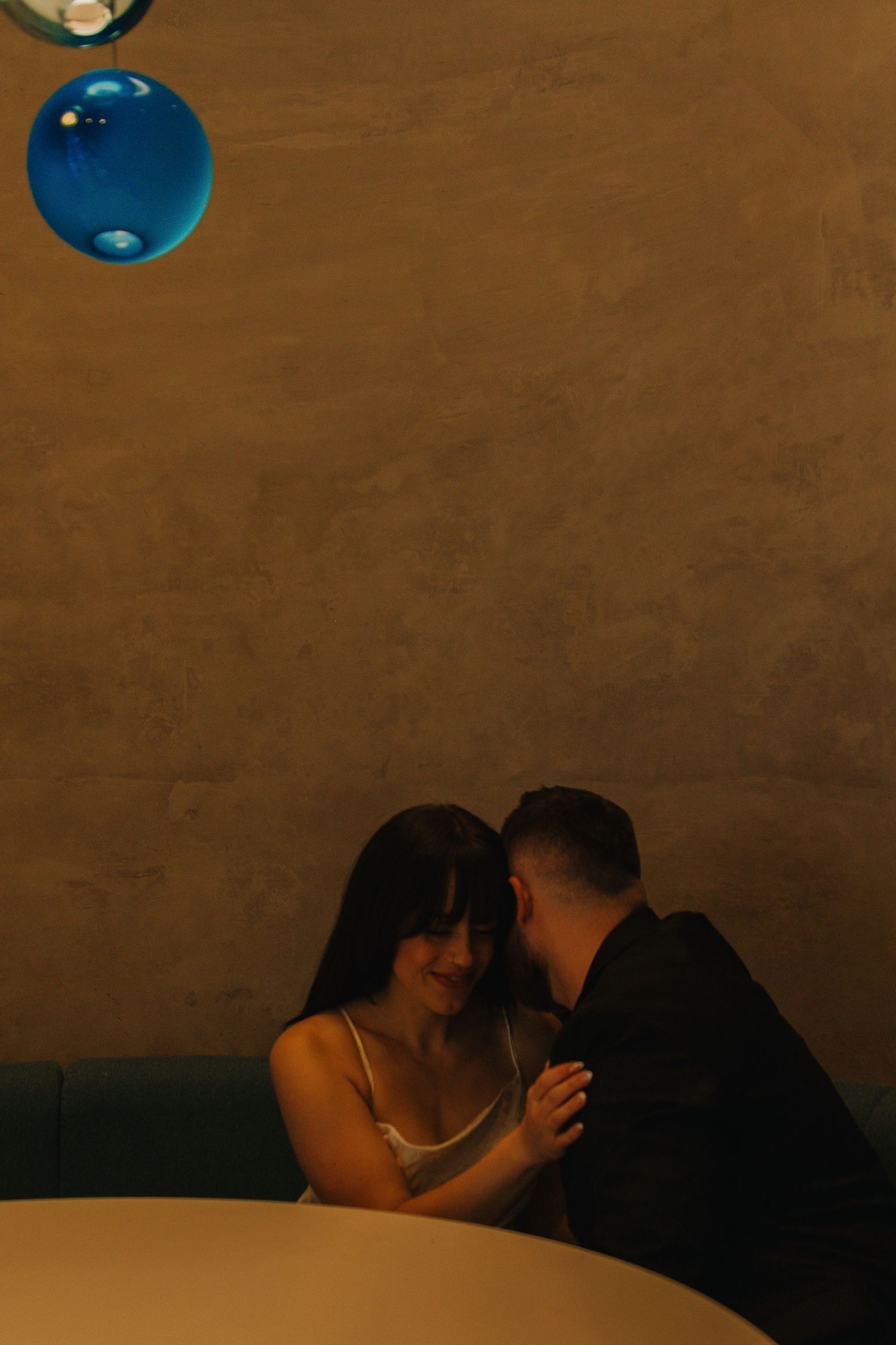 Romantic dance scene with blue pendant lights creating ambient mood lighting.