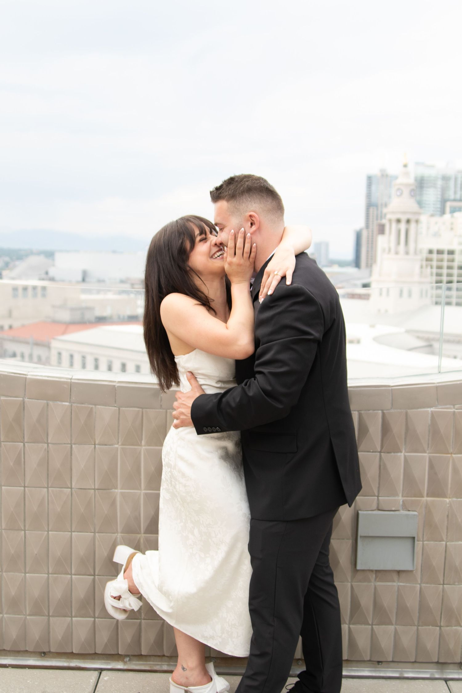 Romantic rooftop moment with city skyline backdrop.