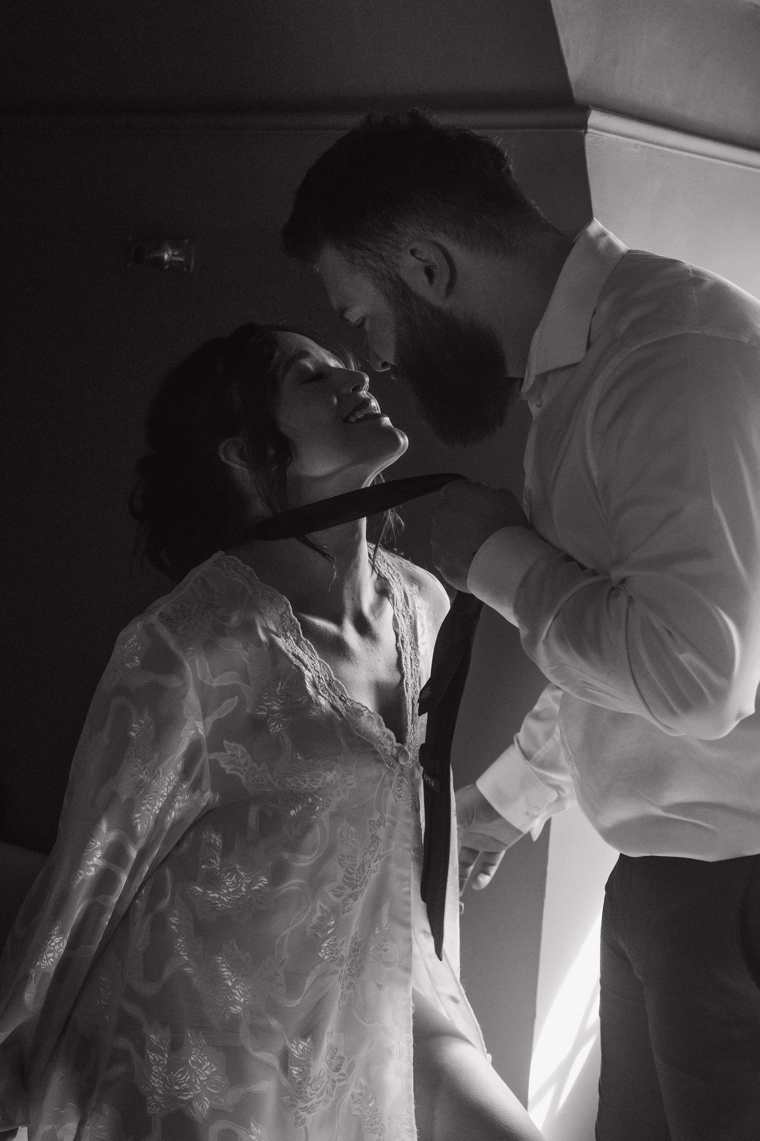 Black and white wedding preparation photos showing close-up details of a white dress and veil.