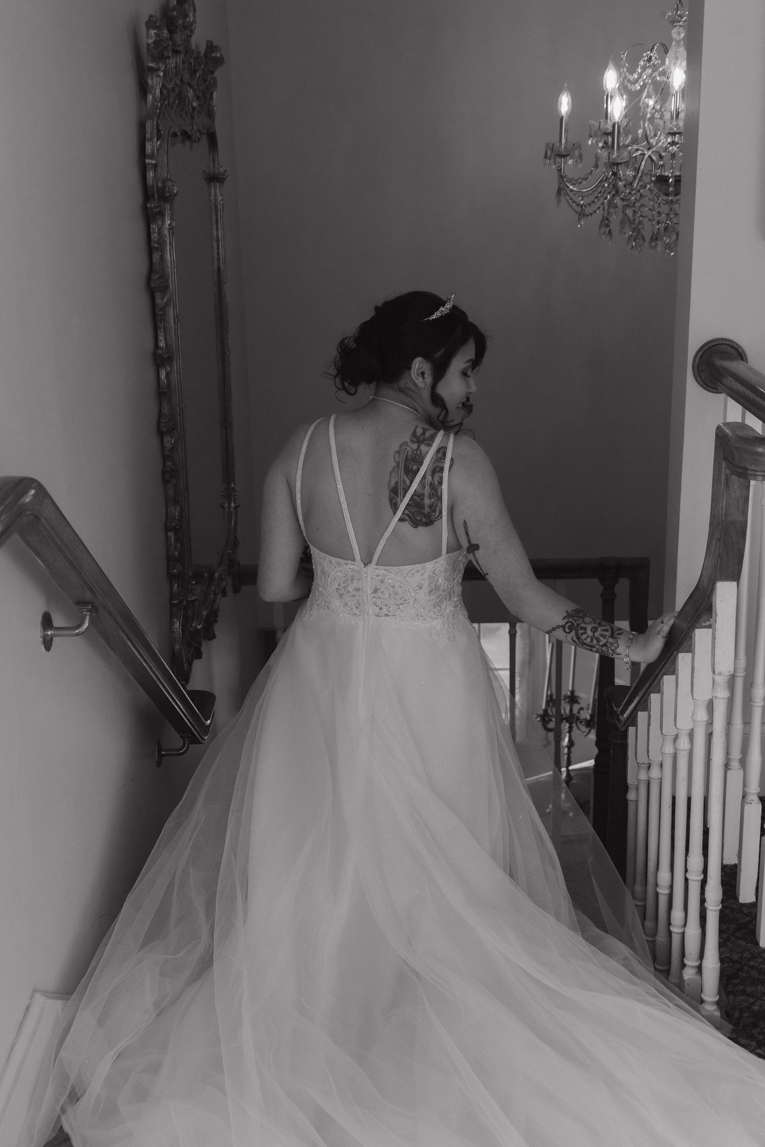 A series of black and white photos showing a bride in a flowing white wedding gown with tulle skirt on a staircase.