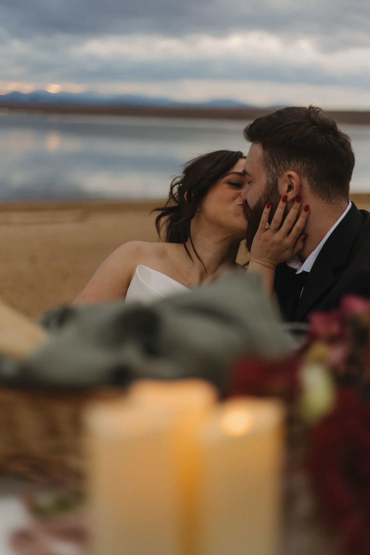 A romantic sunset beach scene with candles and intimate moments.