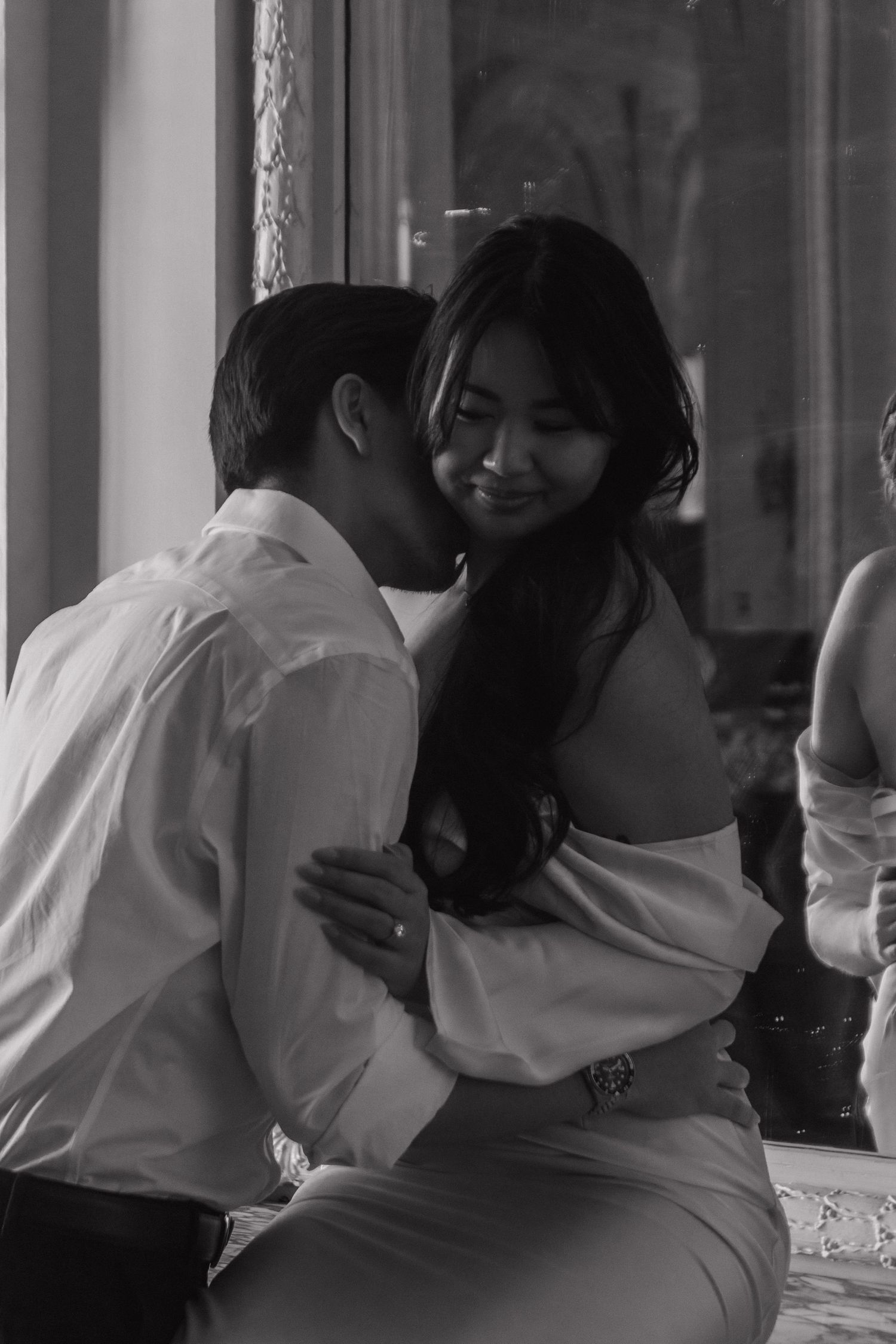 A romantic dance sequence captured in black and white through window reflections.