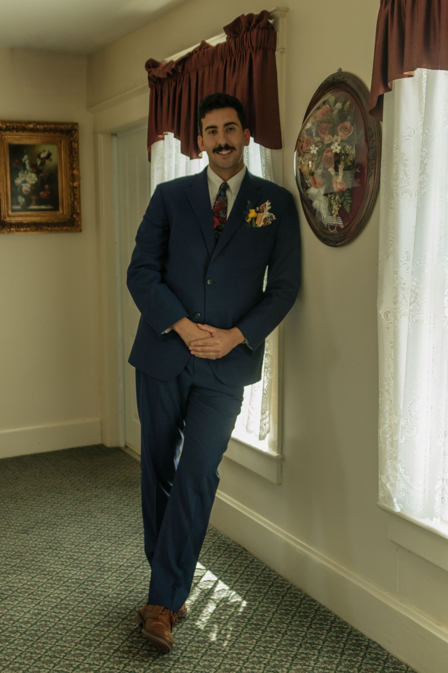 A series of photos showing a figure in a dark suit posing against a light-colored wall with a carpeted floor and window.