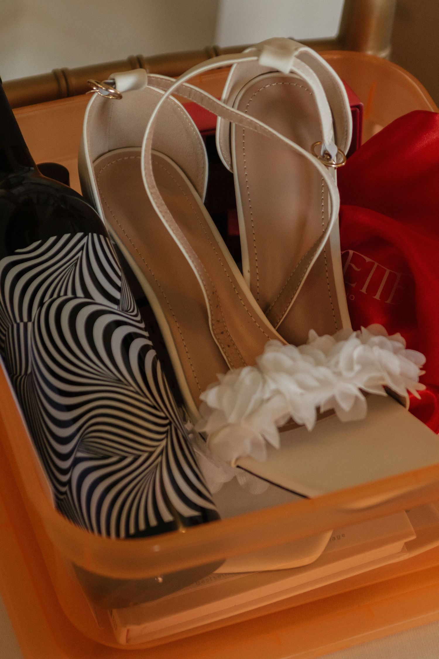 Wedding shoes arranged on an orange surface with zebra print and delicate white floral details.
