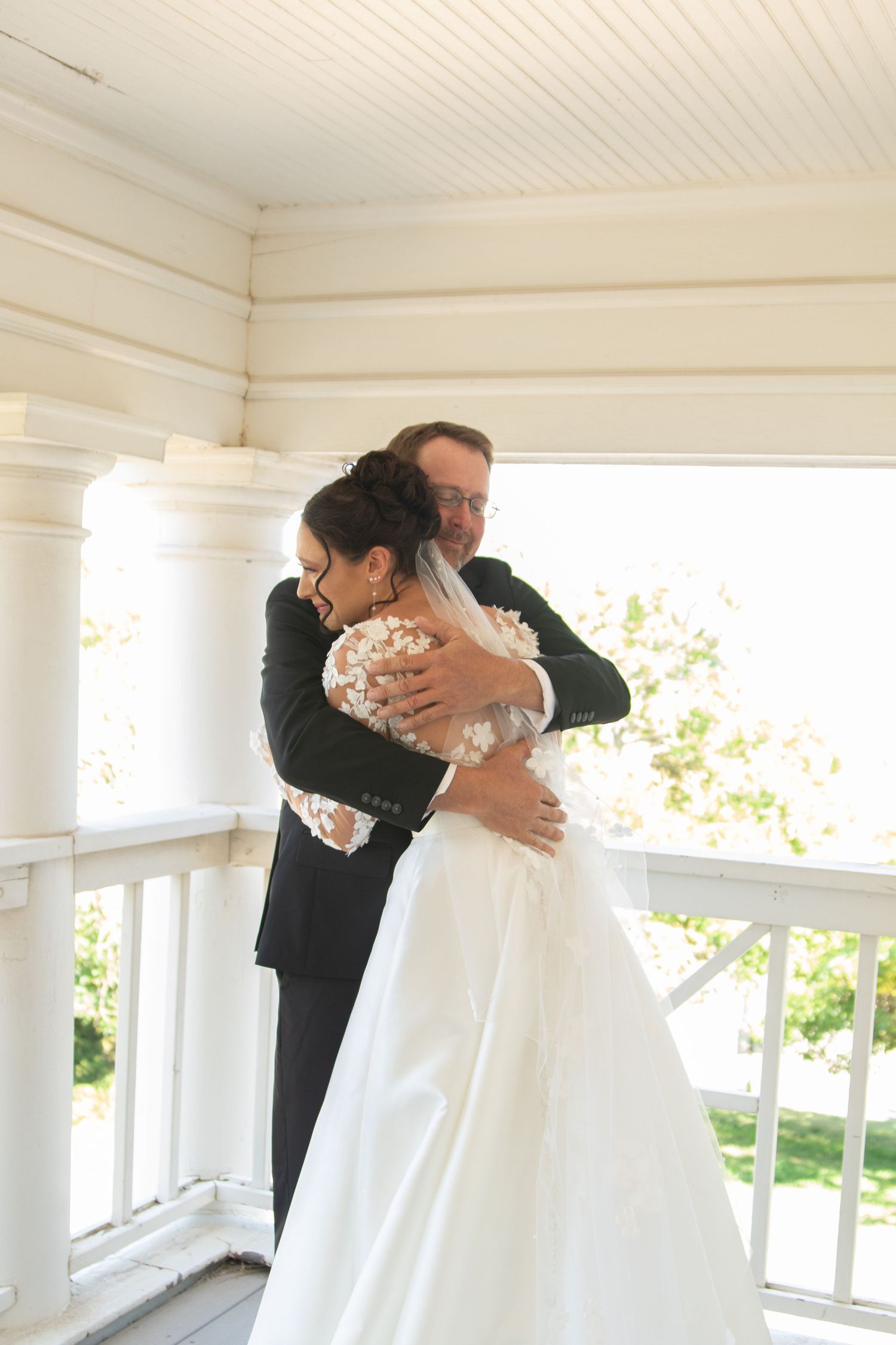 First look moment captured on white porch between couple on wedding day.
