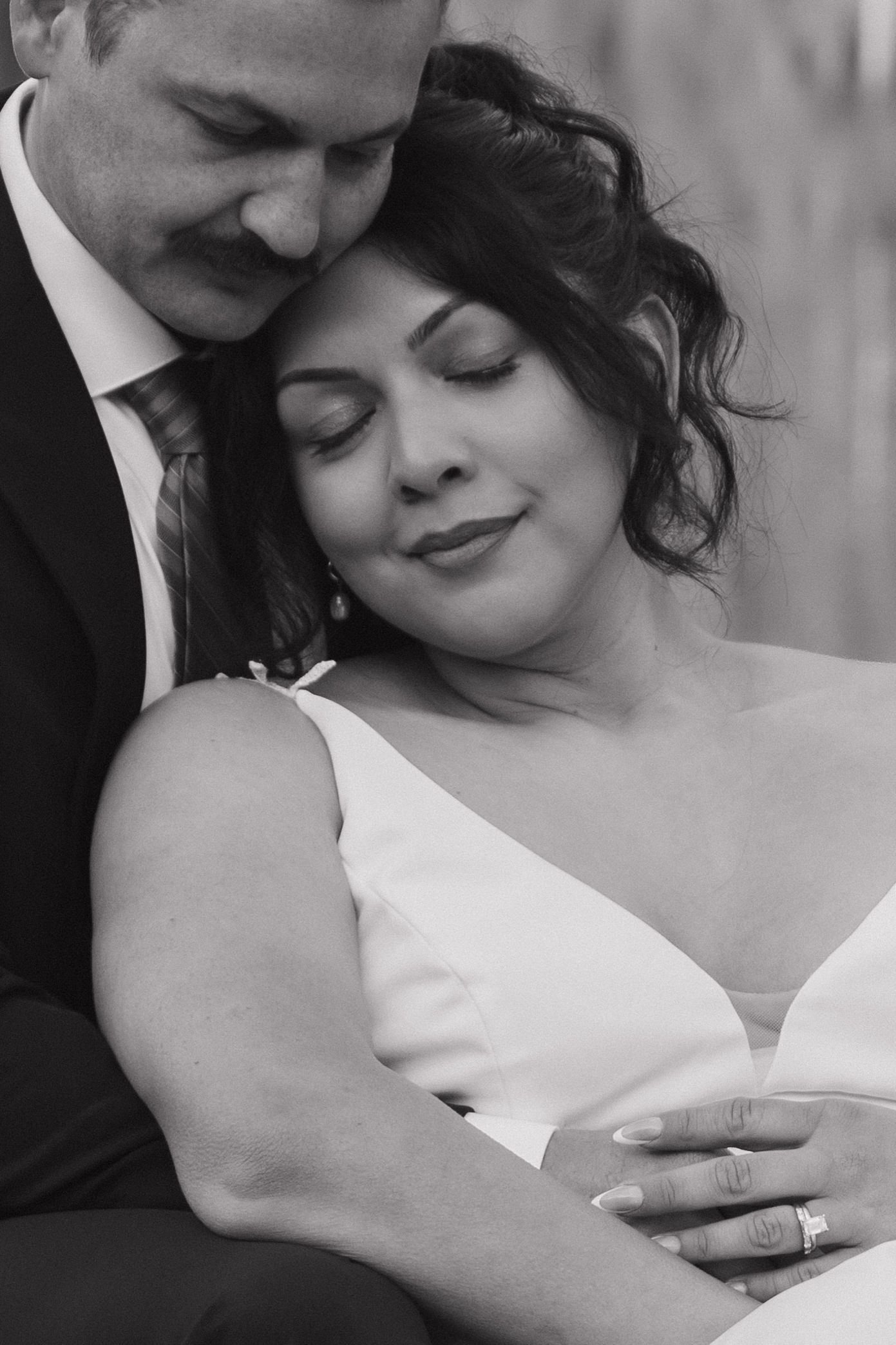 A tender black and white wedding portrait capturing an intimate embrace.