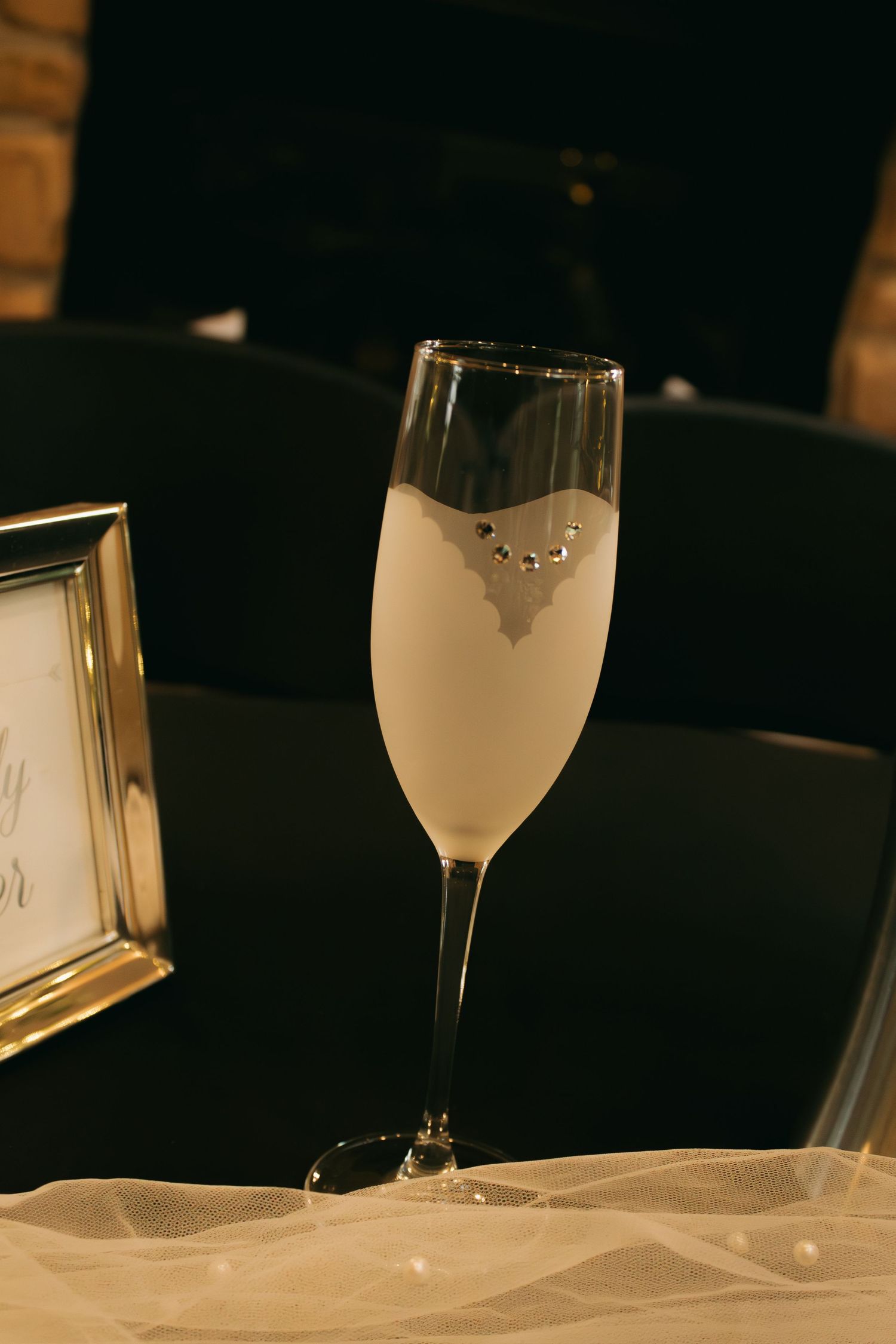 Frosted wine glass on a dark table with elegant lighting and soft focus.