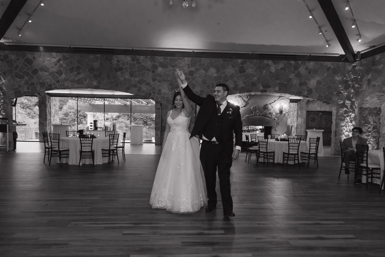 Bride and groom make their grand entrance into the wedding reception ballroom in black and white.