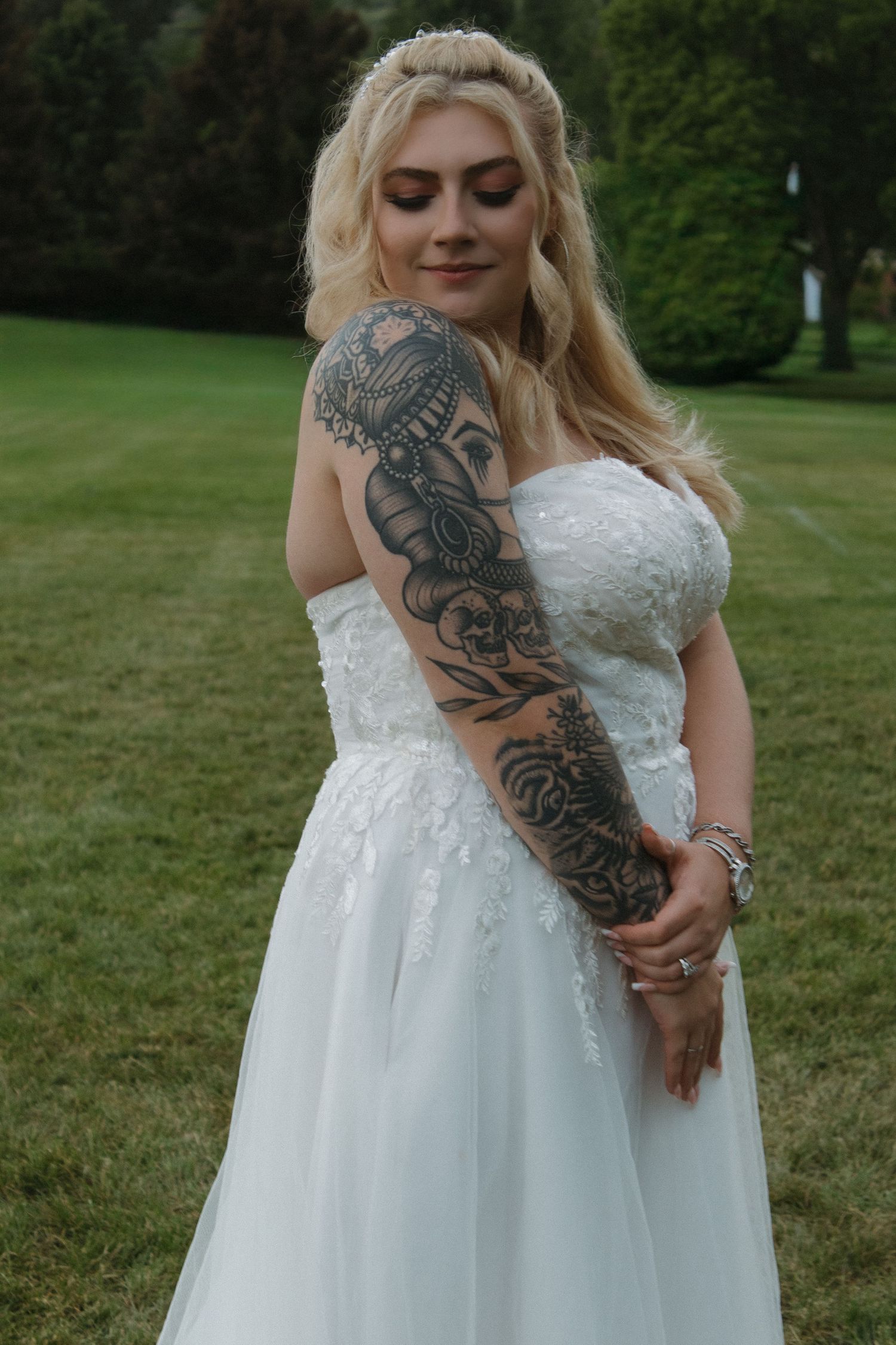 Wedding dress detail shot showing intricate lace bodice and decorative tattoo art.