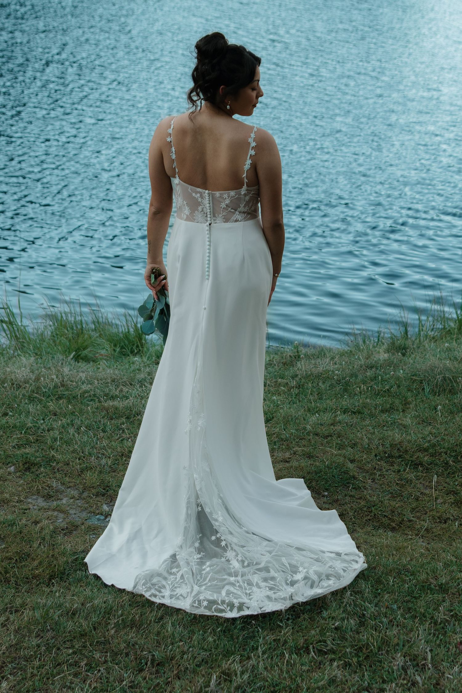 Detail shots of a white wedding dress with lace trim against a lakeside backdrop.
