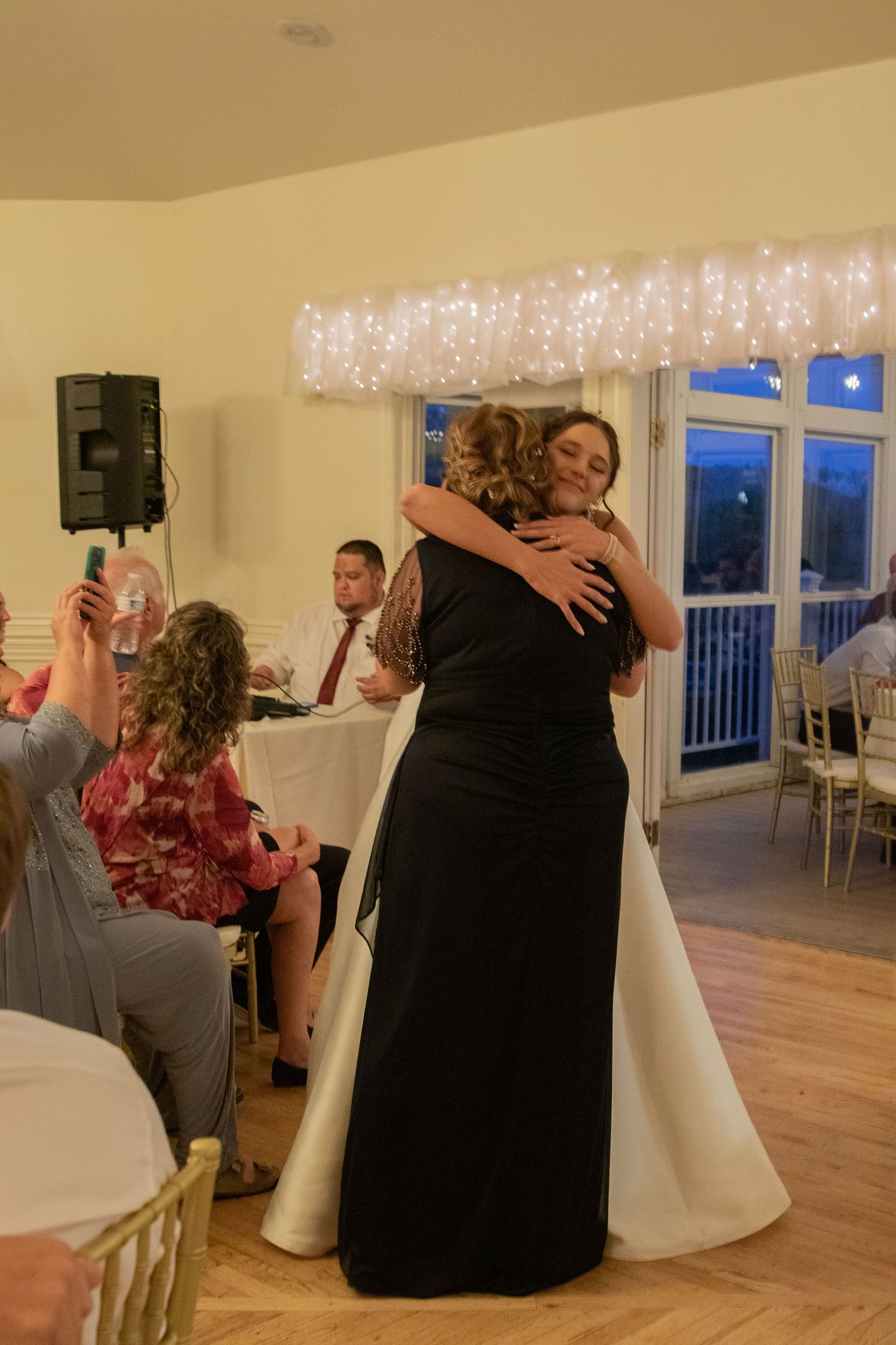 Couples dancing and embracing at a wedding reception with warm ambient lighting.