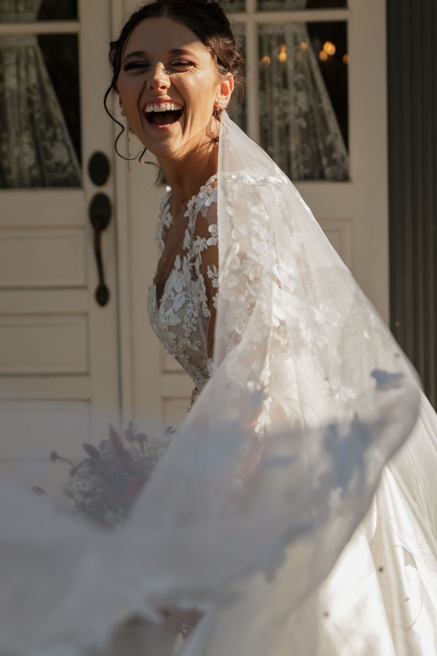 A joyful moment captured in a wedding dress with delicate lace details.