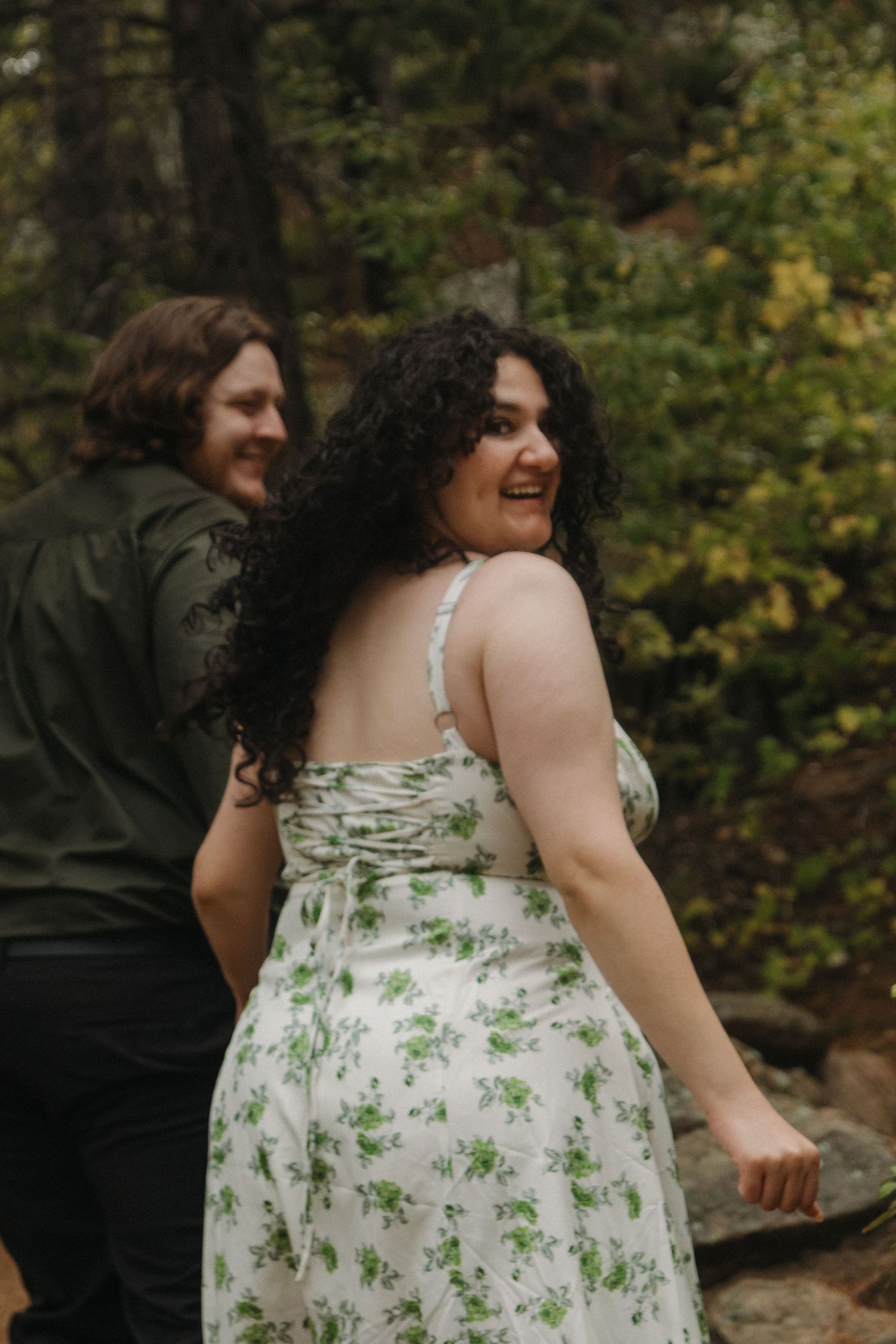A floral dress detail and natural outdoor setting create a romantic atmosphere.