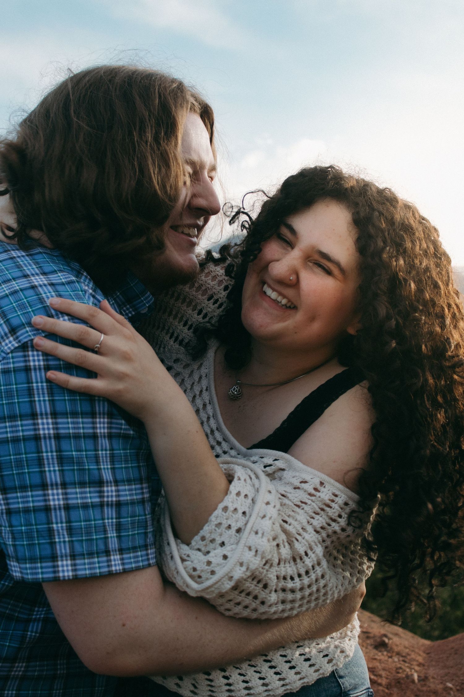A joyful couple sharing laughter and embraces during an outdoor photoshoot.