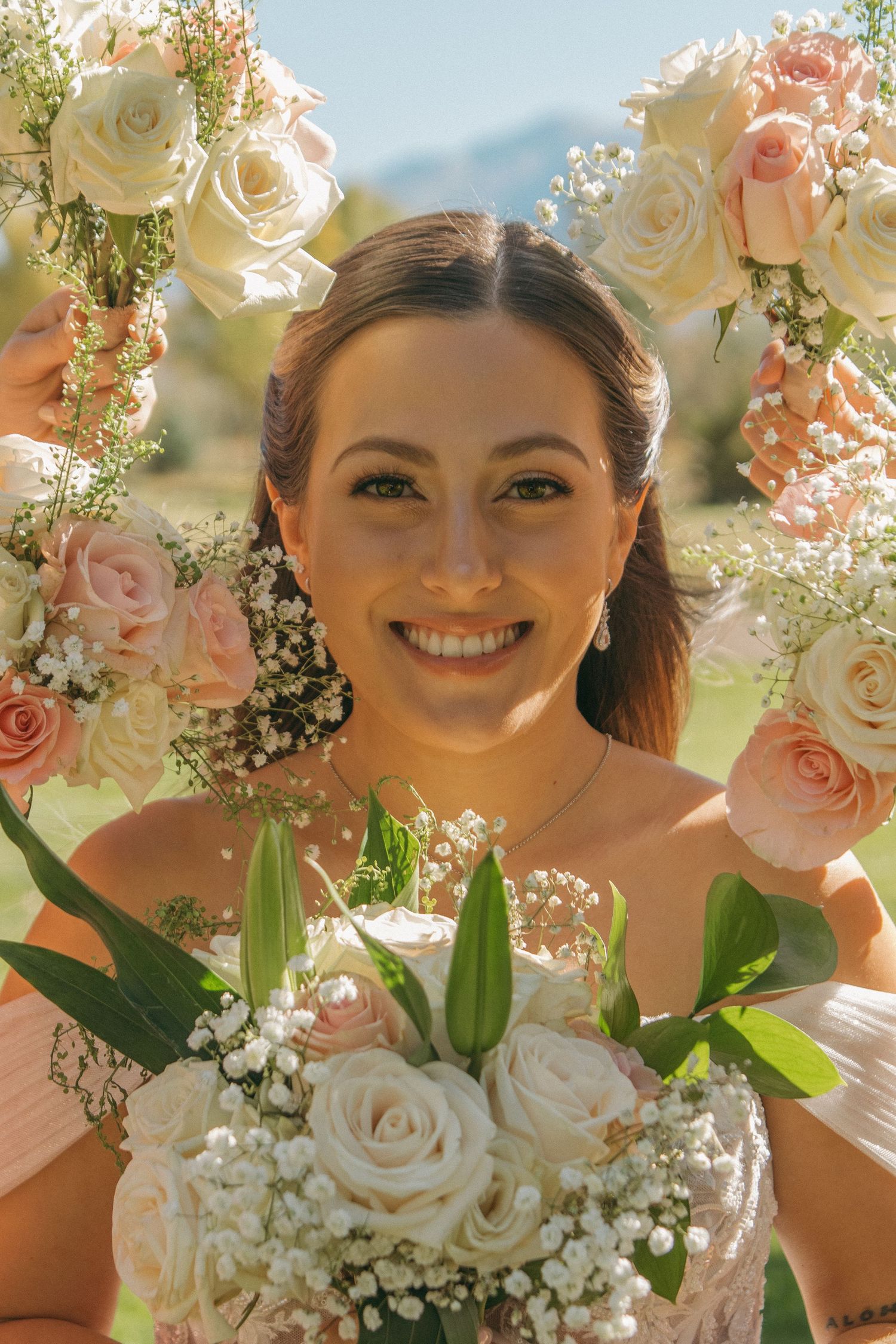 Beautiful wedding bouquet with white roses and pink accents against a soft natural background.