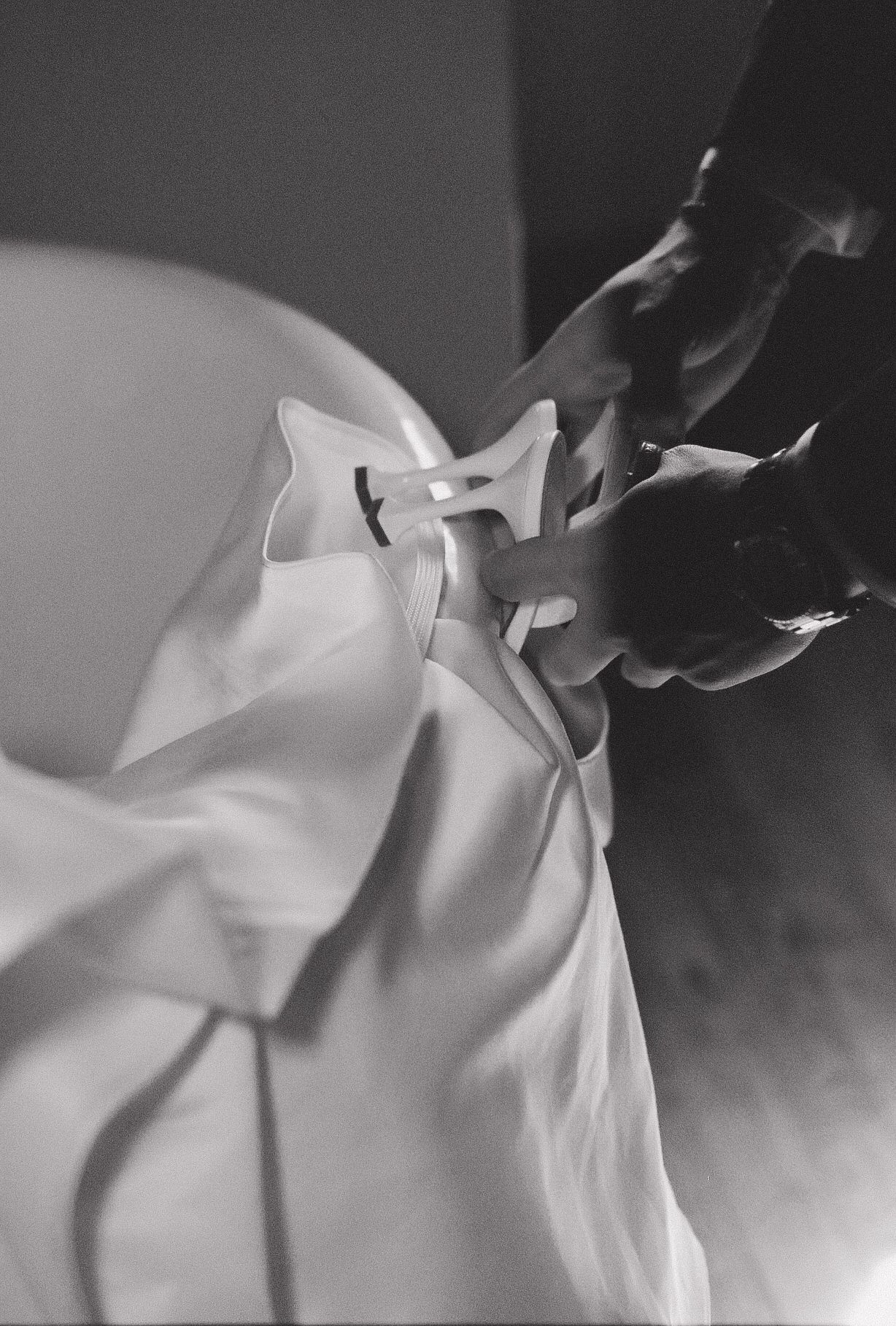 Black and white close-up of delicate wedding dress details and fabric.