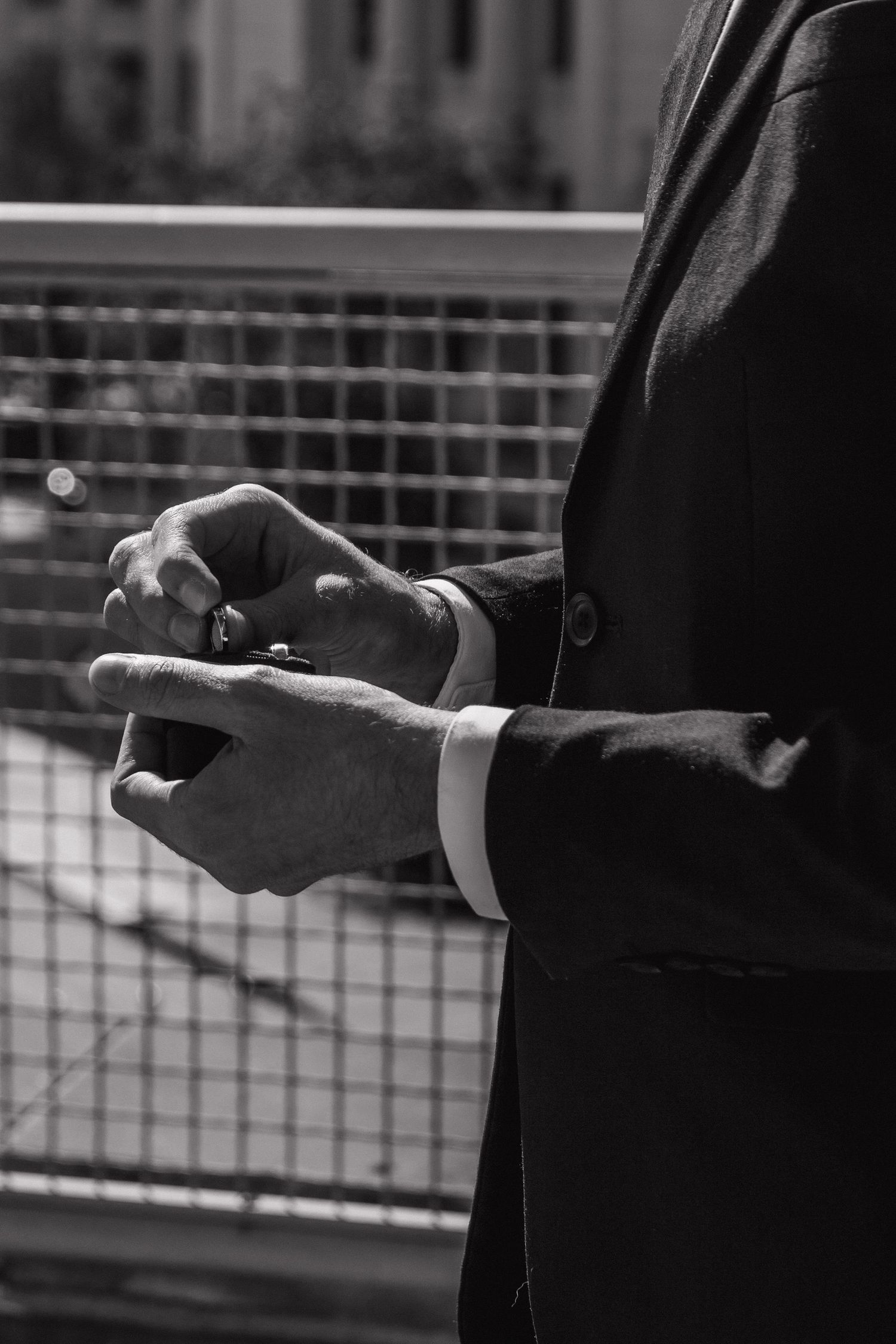 Black and white close-up sequence of hands exchanging rings during wedding ceremony.