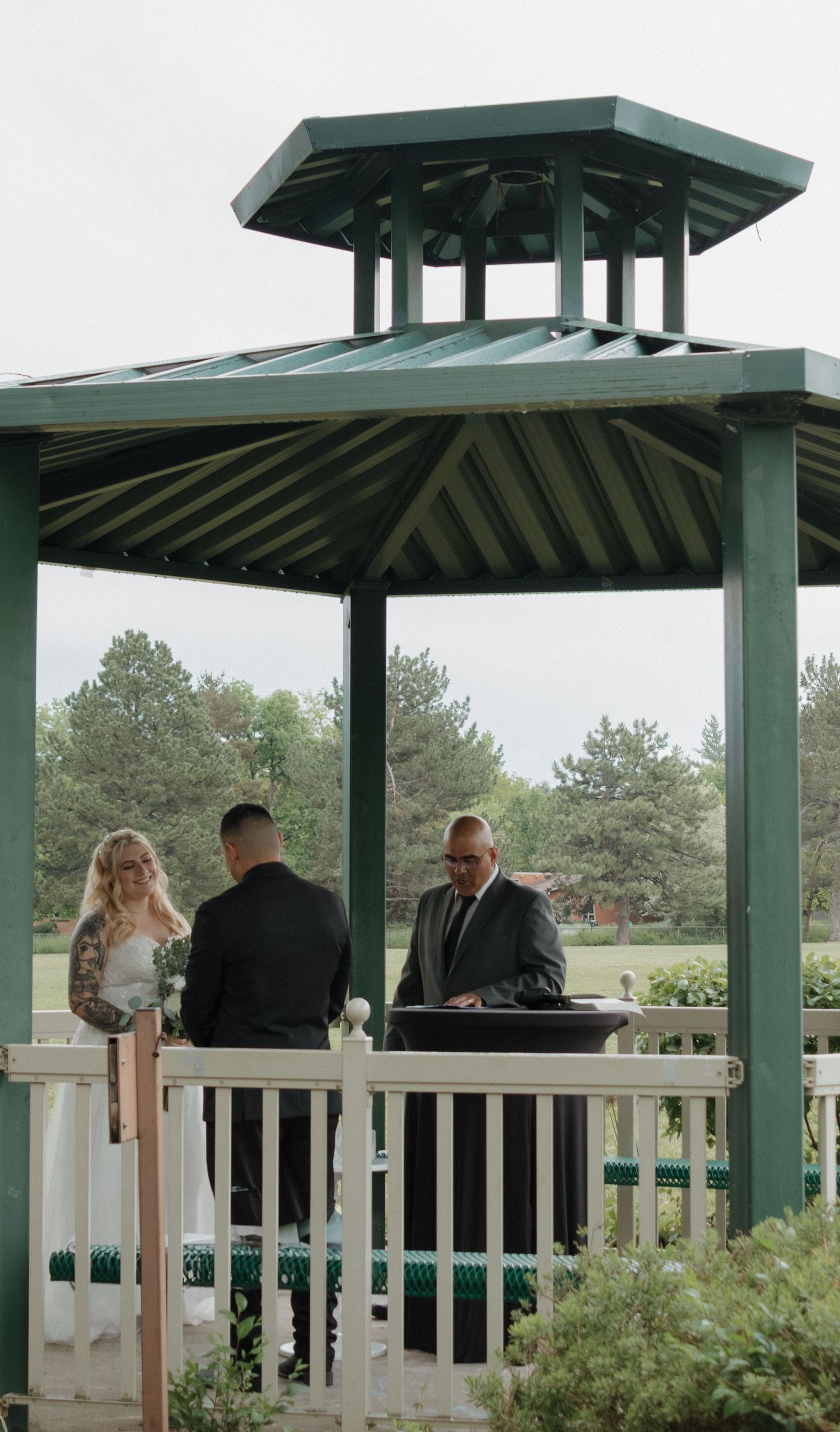 Wedding guests and party members gathered on covered deck with green roof.