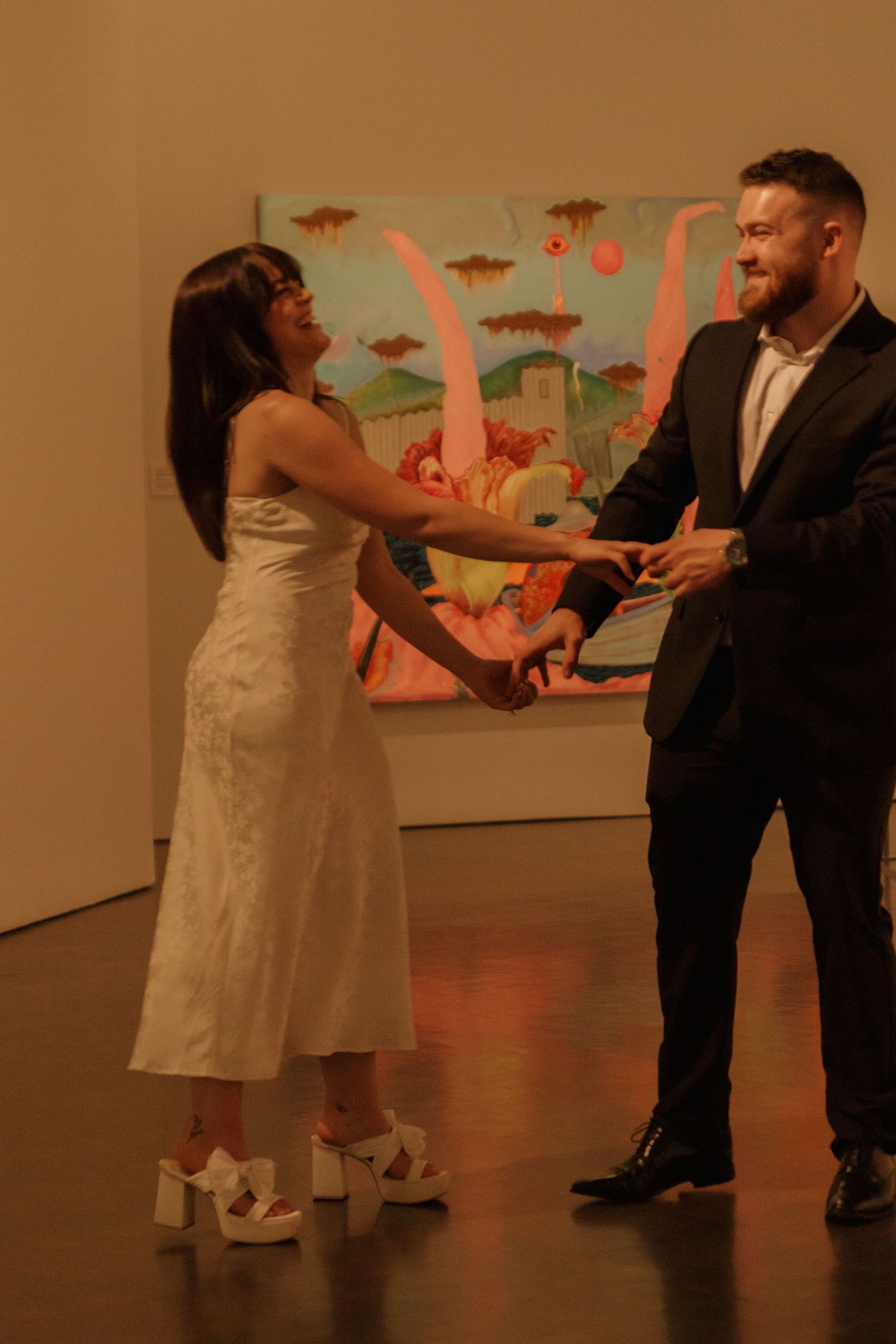 Dancing sequence in an art gallery with colorful artwork visible in the background.