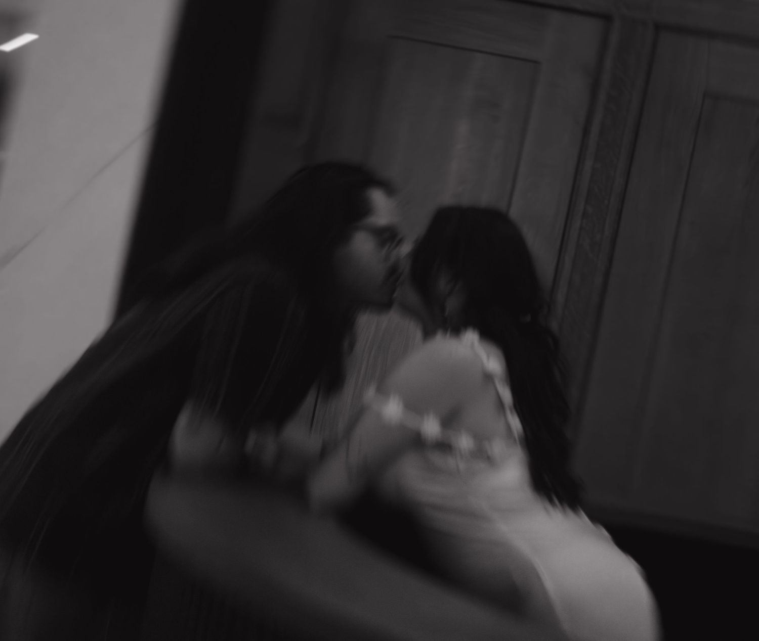 Artistic black and white photo of a couple in an intimate moment.