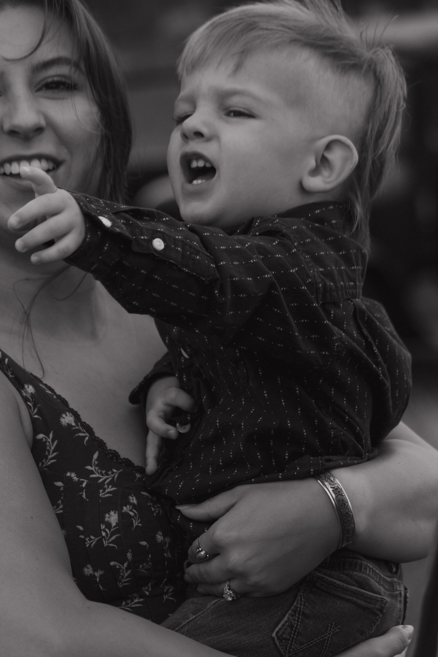 Black and white candid moment of pure joy and laughter captured outdoors.