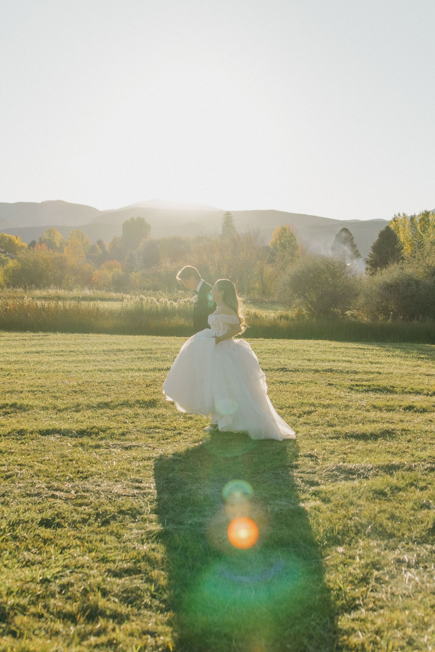Sun-drenched meadow with couple sitting together in golden afternoon light.