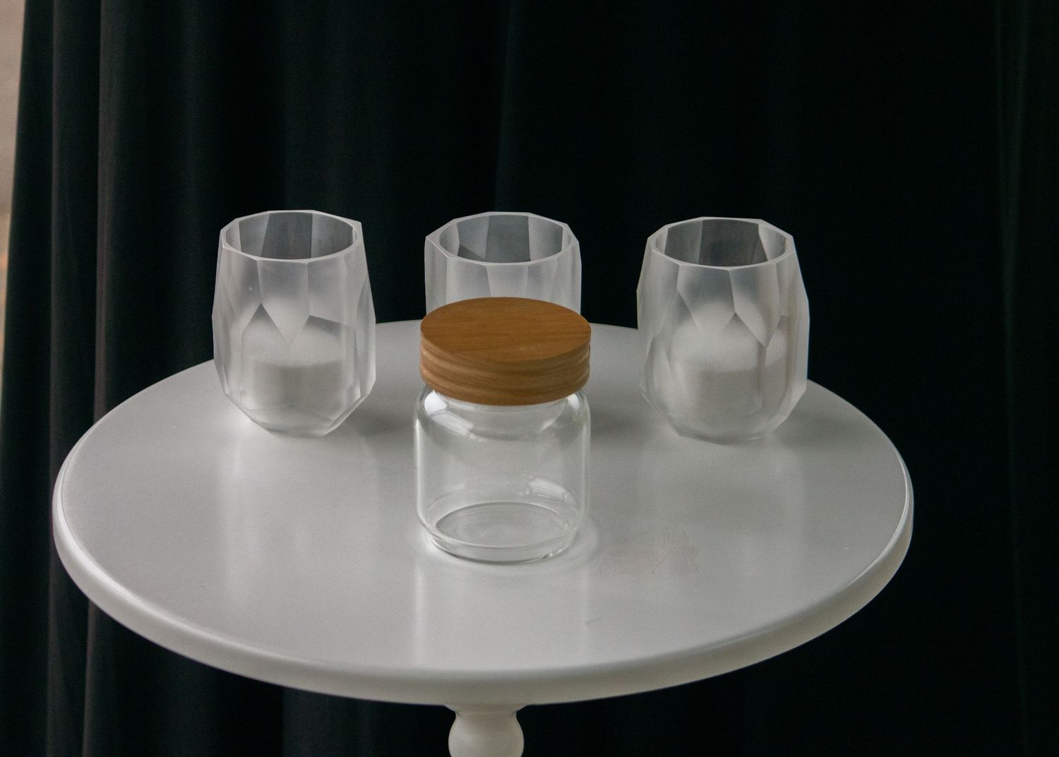 White pedestal display with clear glass jars arranged neatly.