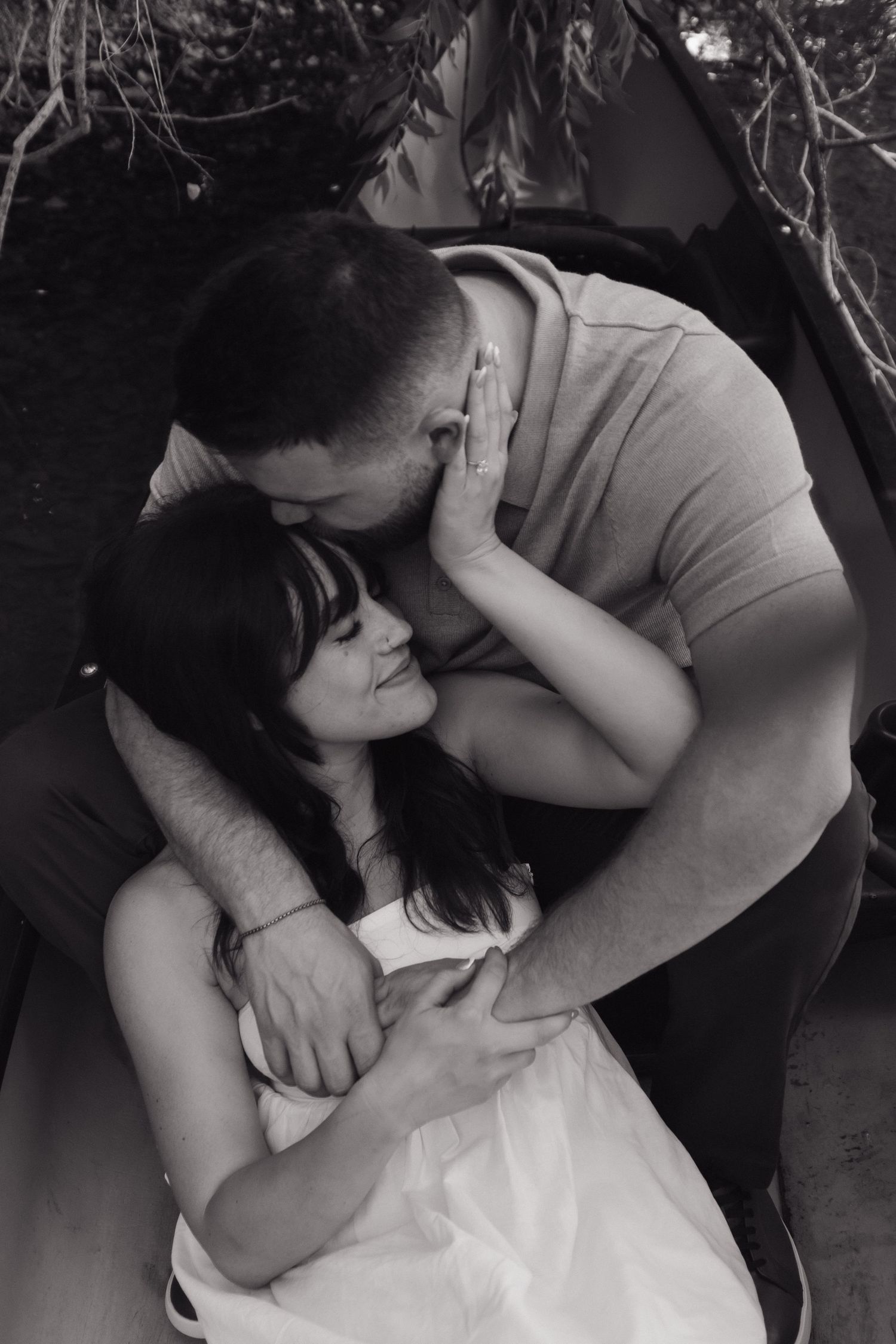 A black and white intimate portrait of two people sharing a loving embrace.