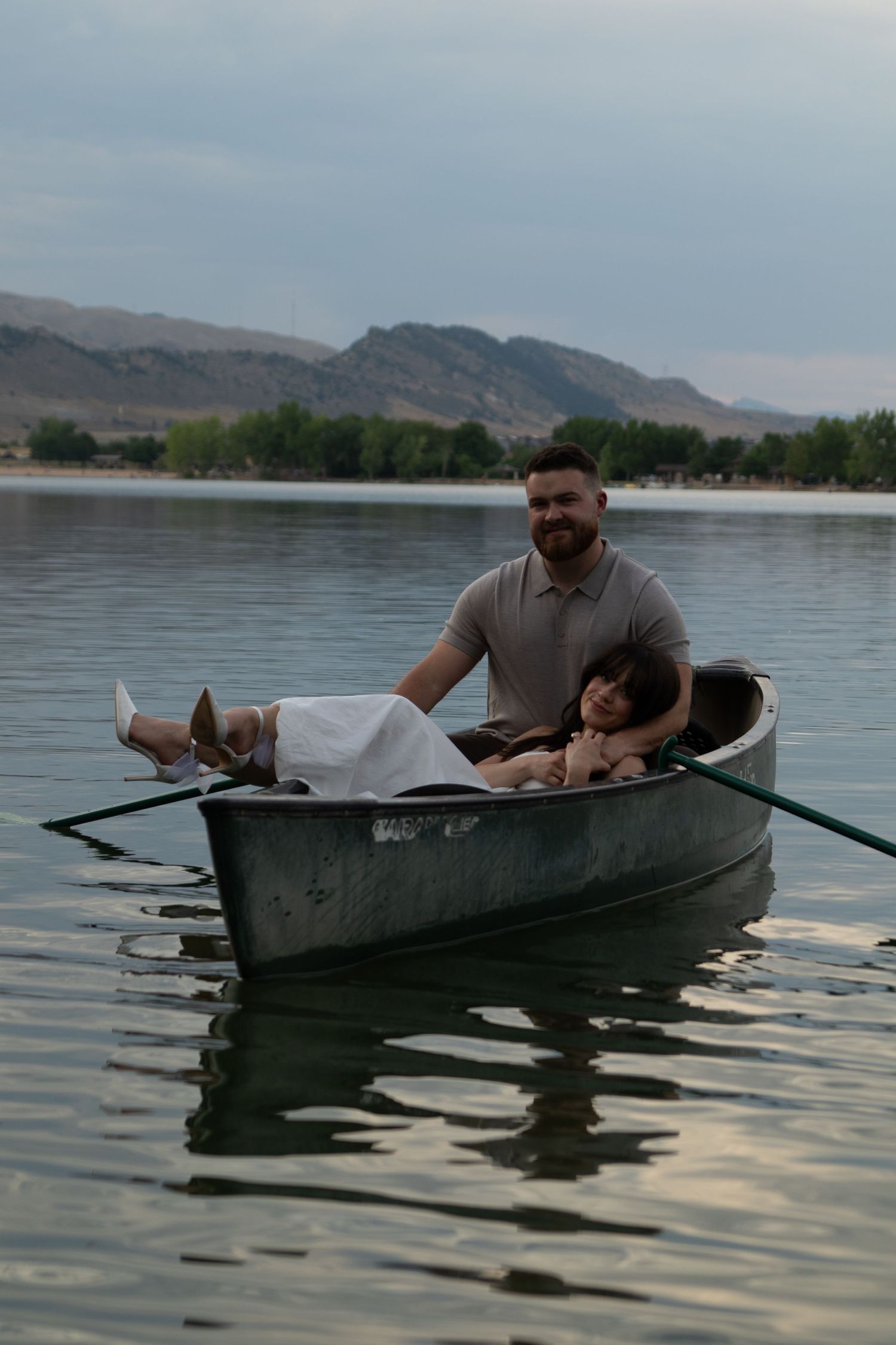 A peaceful canoe ride on reflective waters with mountains in the background.
