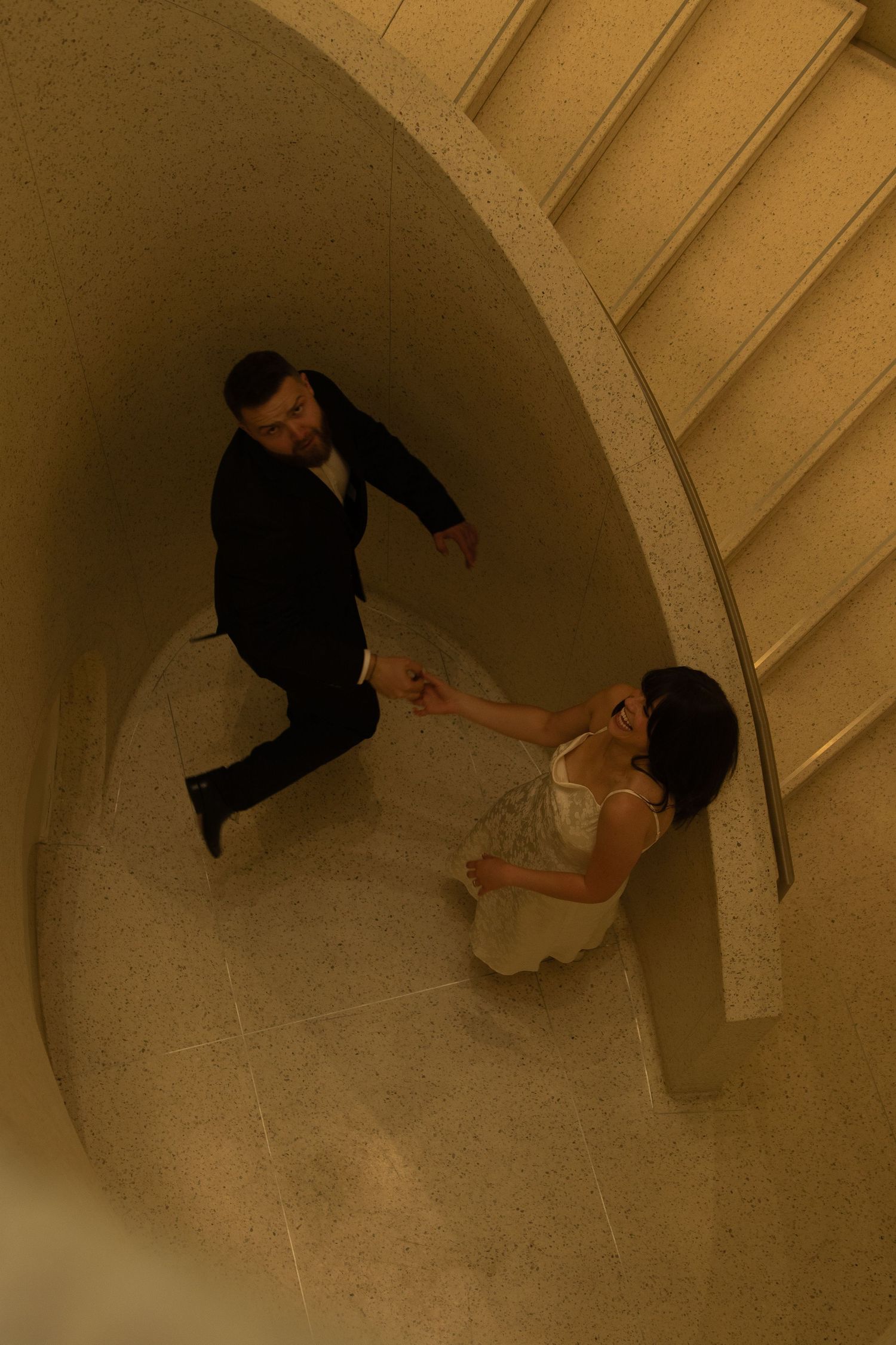 Birds-eye view of a dancing couple through an arched architectural space.