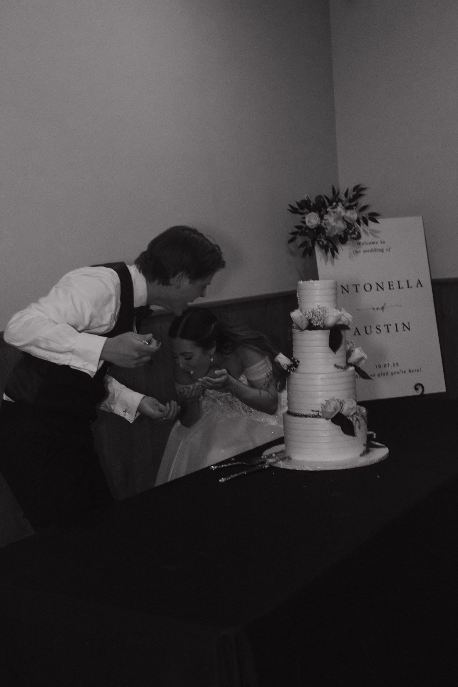 Black and white series showing someone decorating a wedding cake.