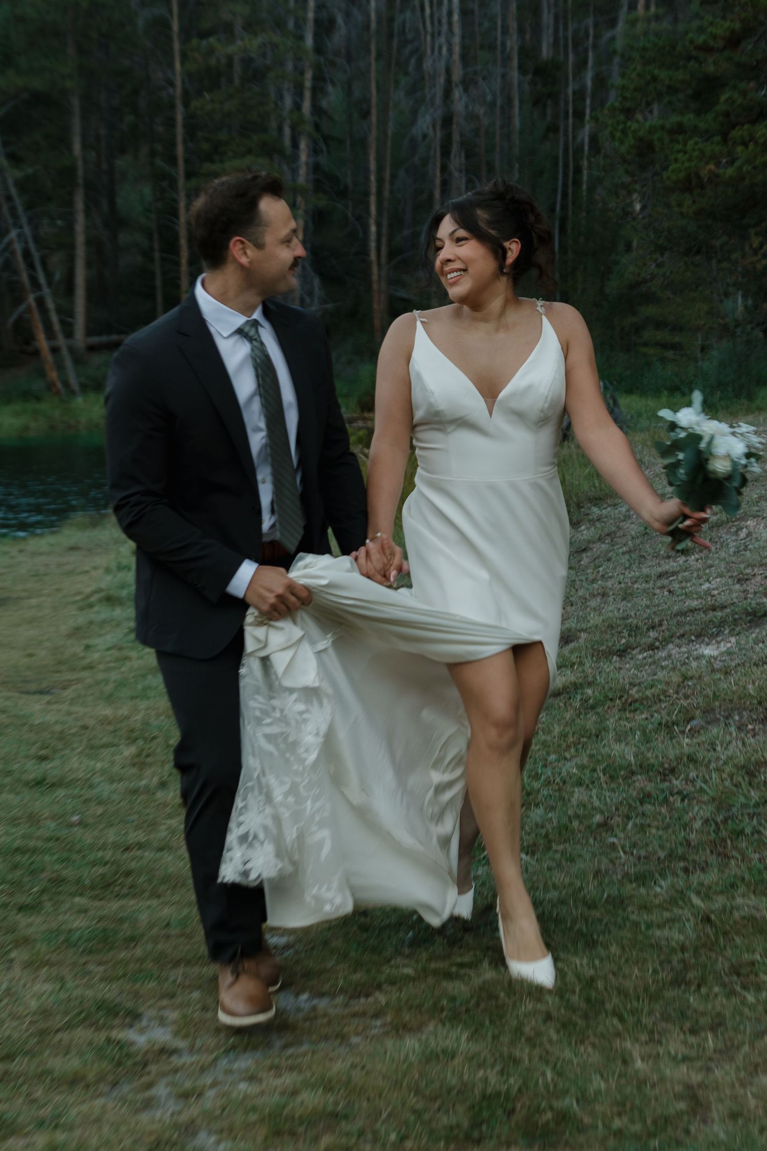Newlyweds share candid moments during their lakeside wedding photo session.