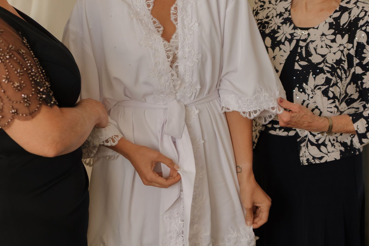 Close-up detail of black and white formal wear with lace embellishments.