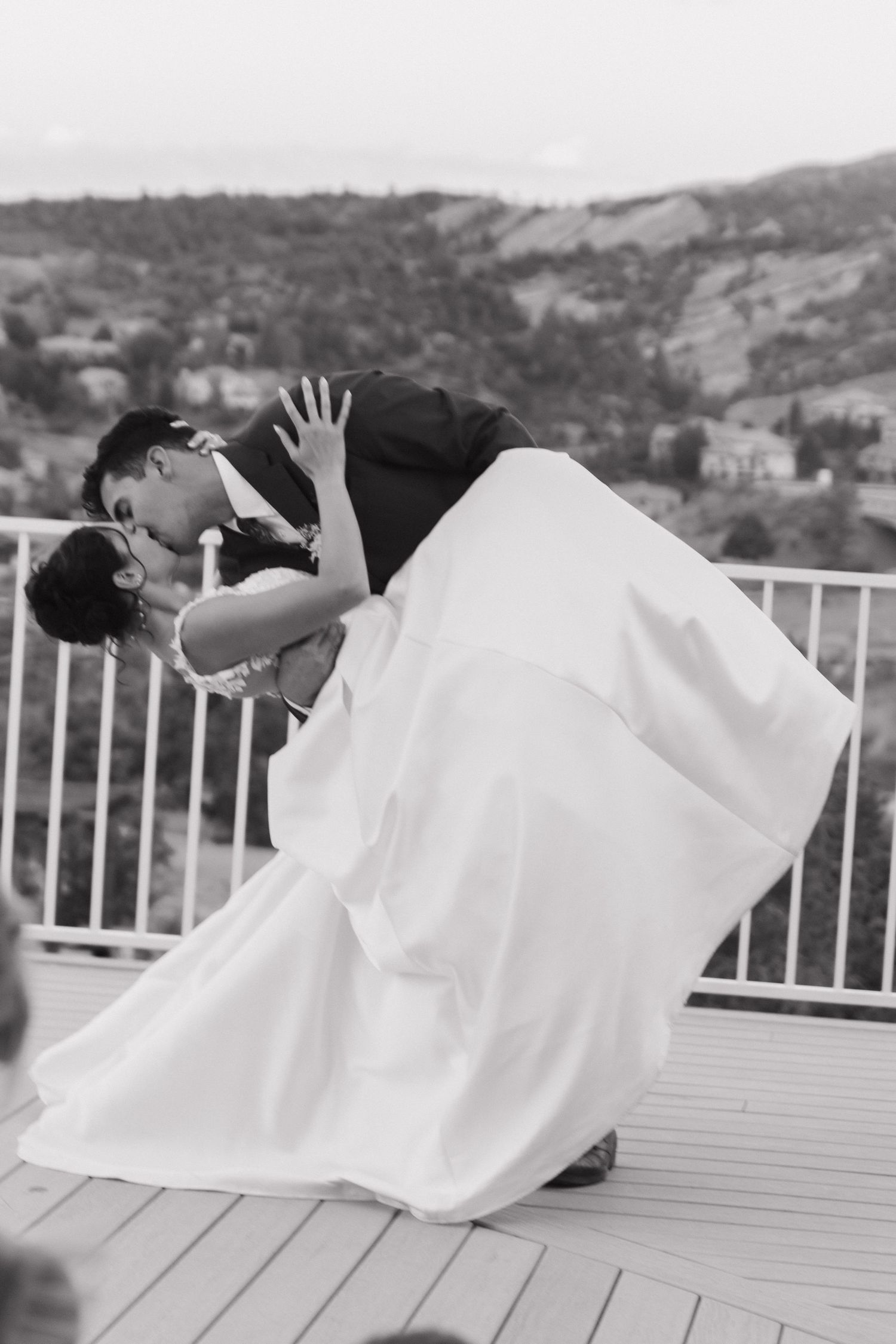 Dramatic wedding photo series taken on a deck with mountain views in the background.
