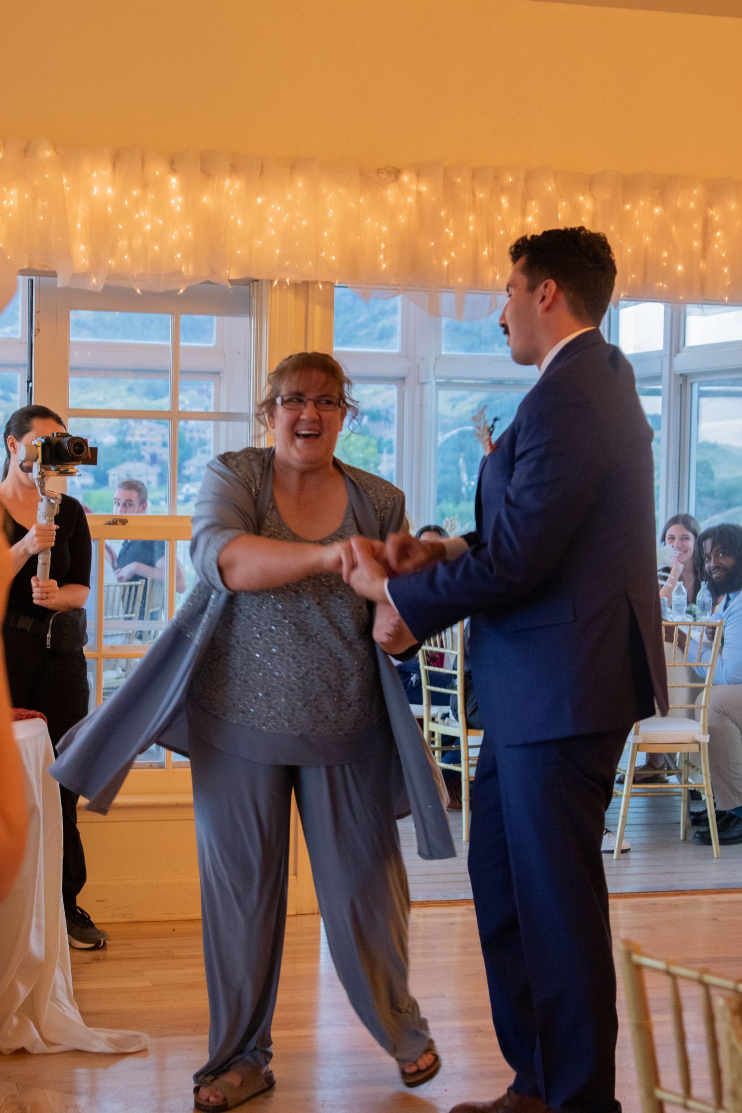 Dance floor moment at wedding reception under string lights.