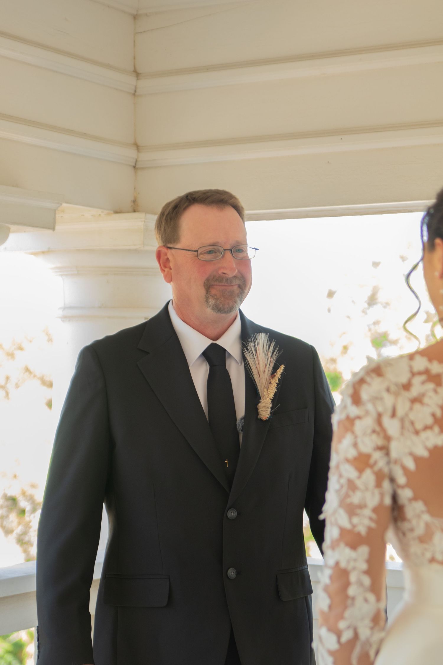 A formal wedding ceremony setup outdoors with stone pillars and decorative lighting.