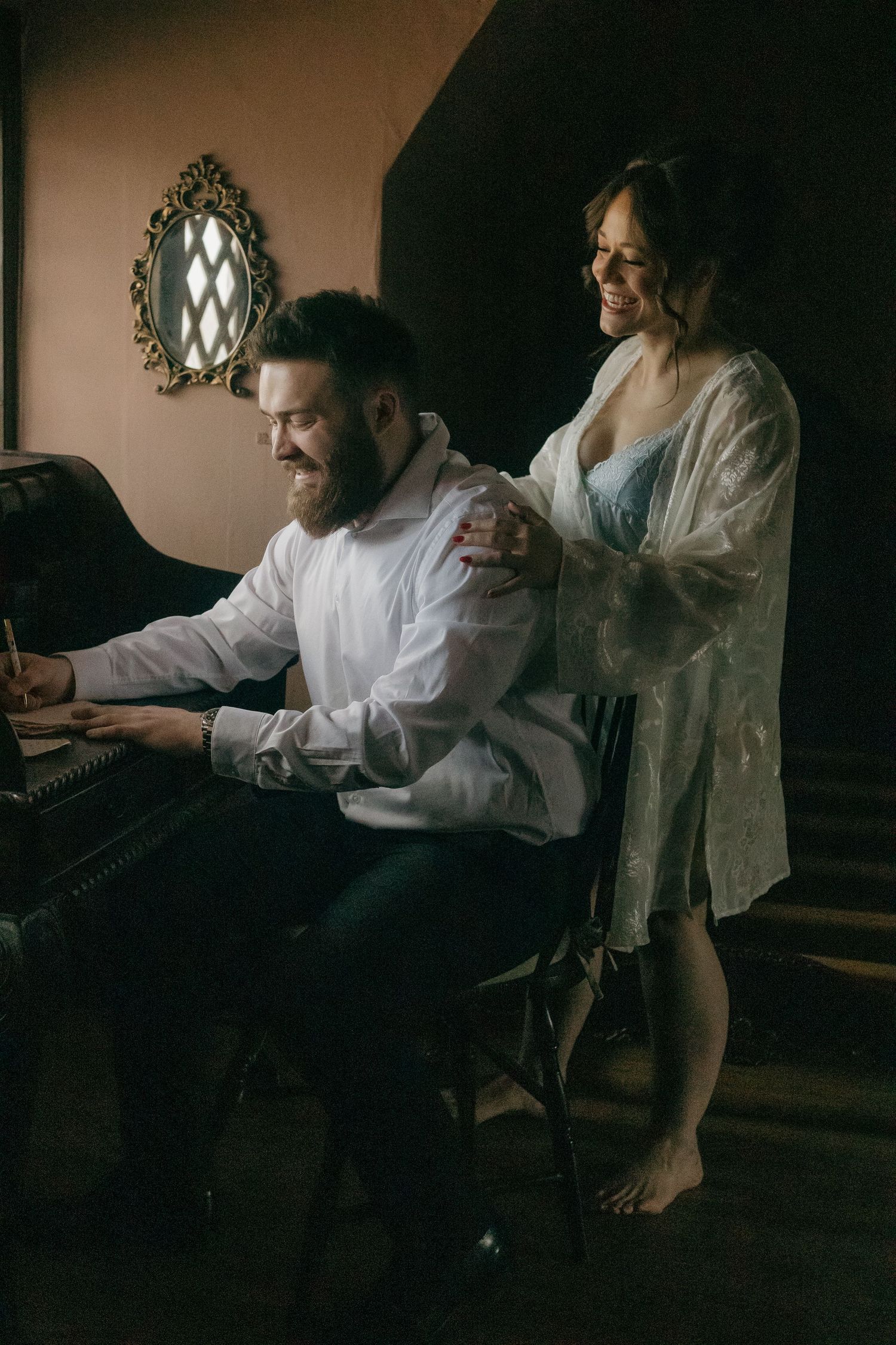 Atmospheric scene of people in white clothing sitting in a dimly lit room with vintage decor.