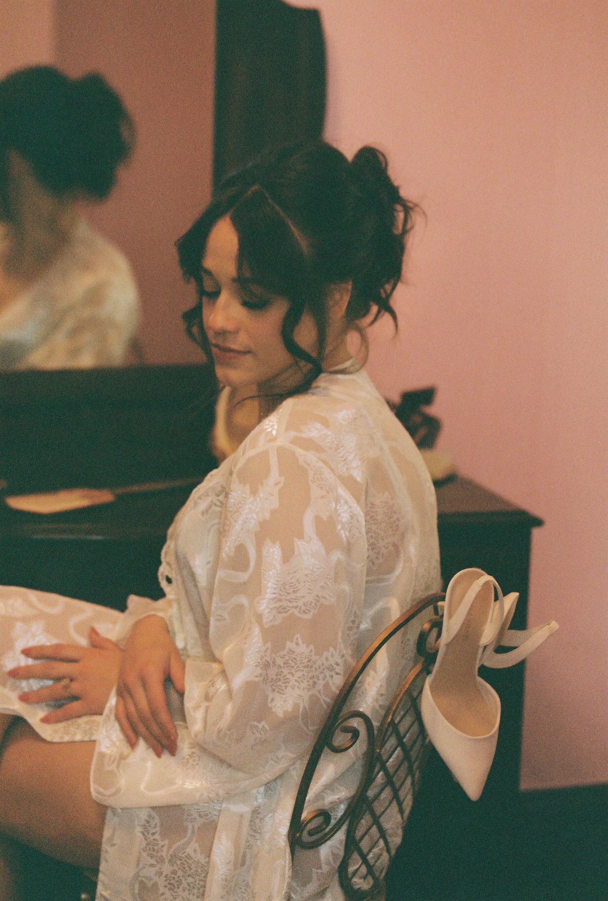 A candid getting-ready moment showing delicate lace details and elegant wedding preparations.