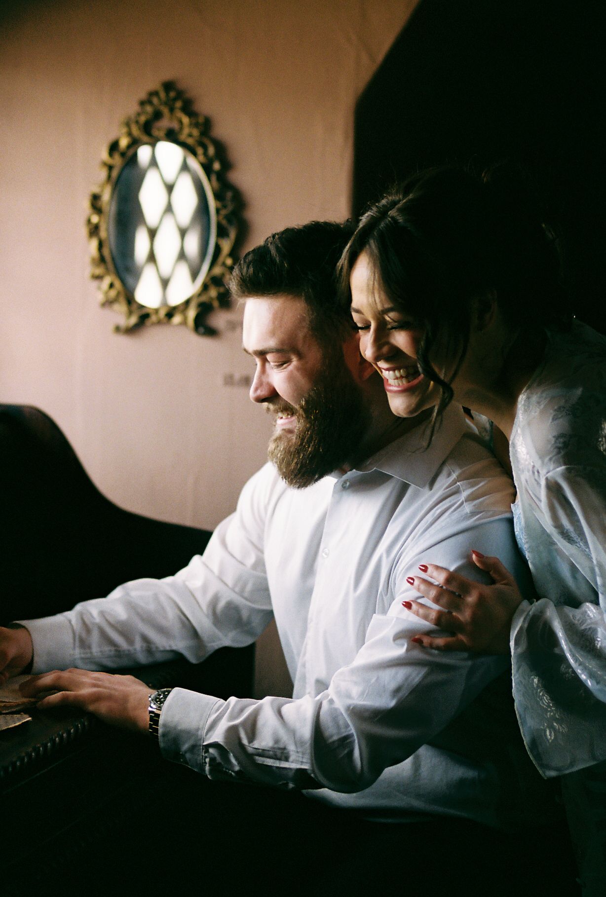 A series of intimate photos showing a couple in white clothing sitting together in a dimly lit room.