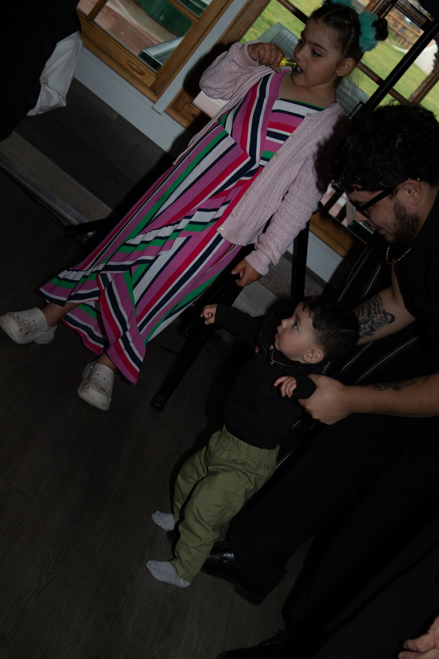 Party guests dancing and socializing in a dark room with colorful geometric patterns.