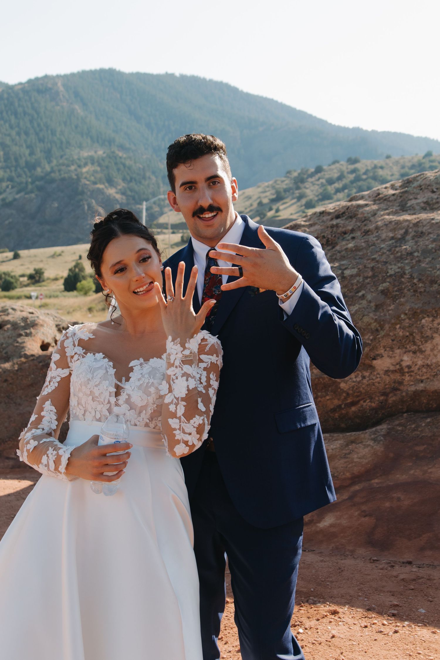 A couple shares joyful expressions during their outdoor mountain wedding.