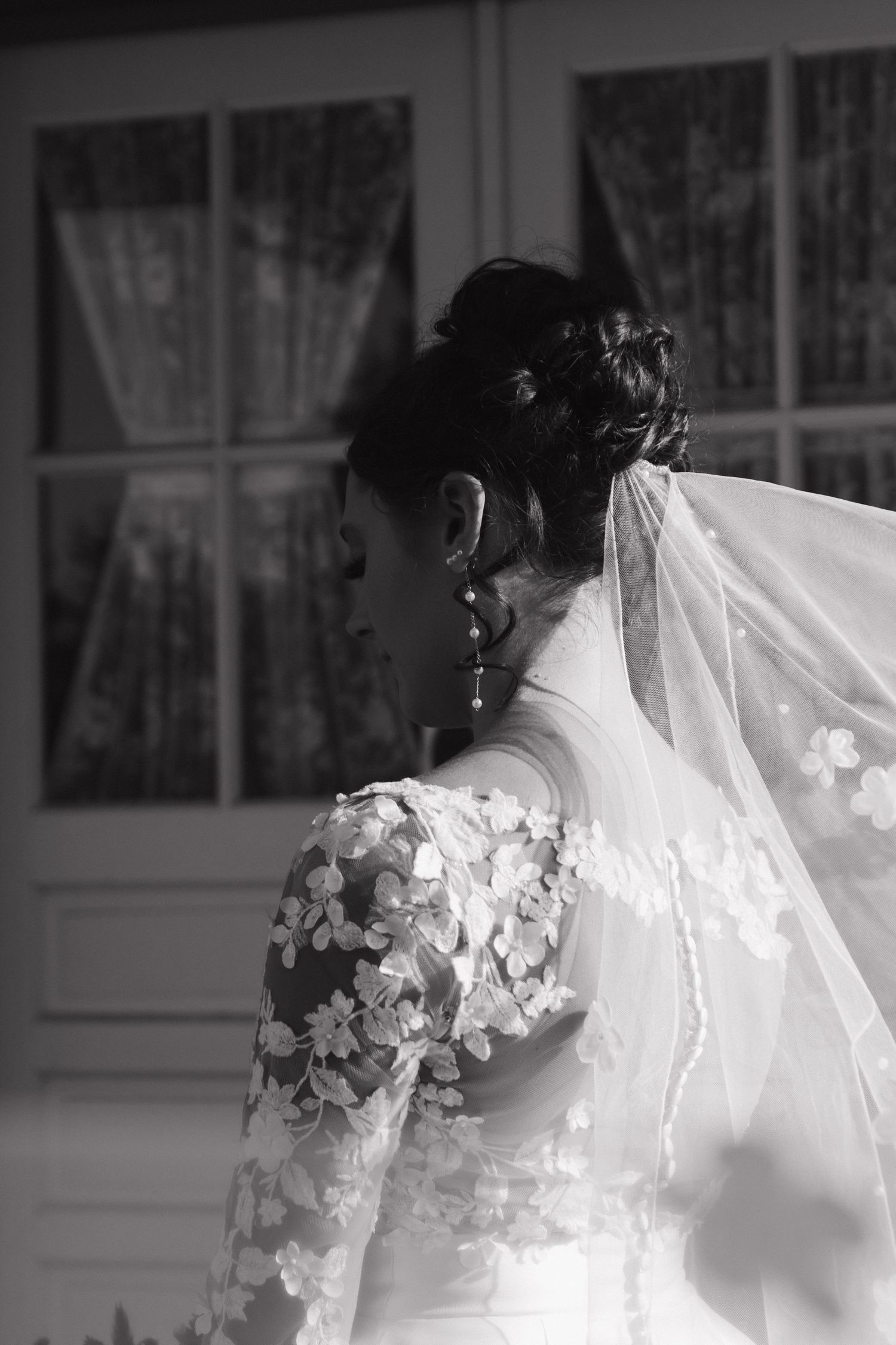 Black and white detail shot of wedding dress with floral lace appliques.