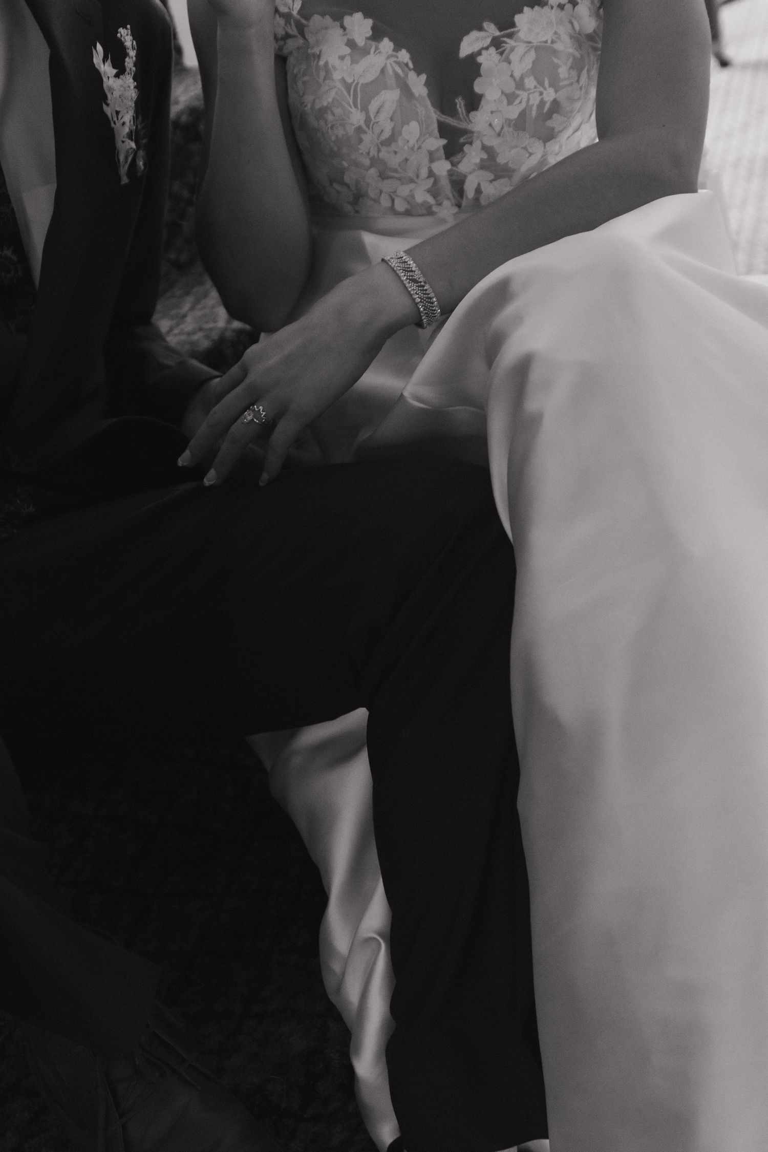 Wedding couple holding hands against a black and white lace wedding dress background.