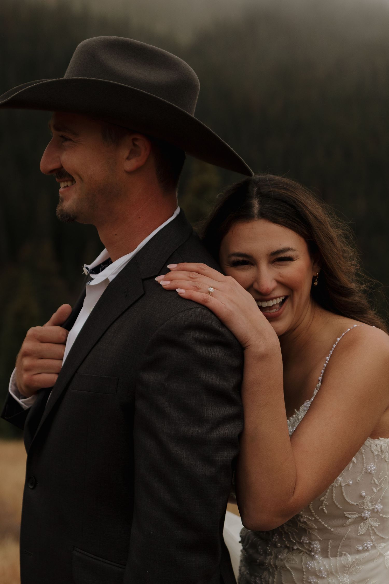 A joyful couple shares laughter during their mountain wedding photoshoot.