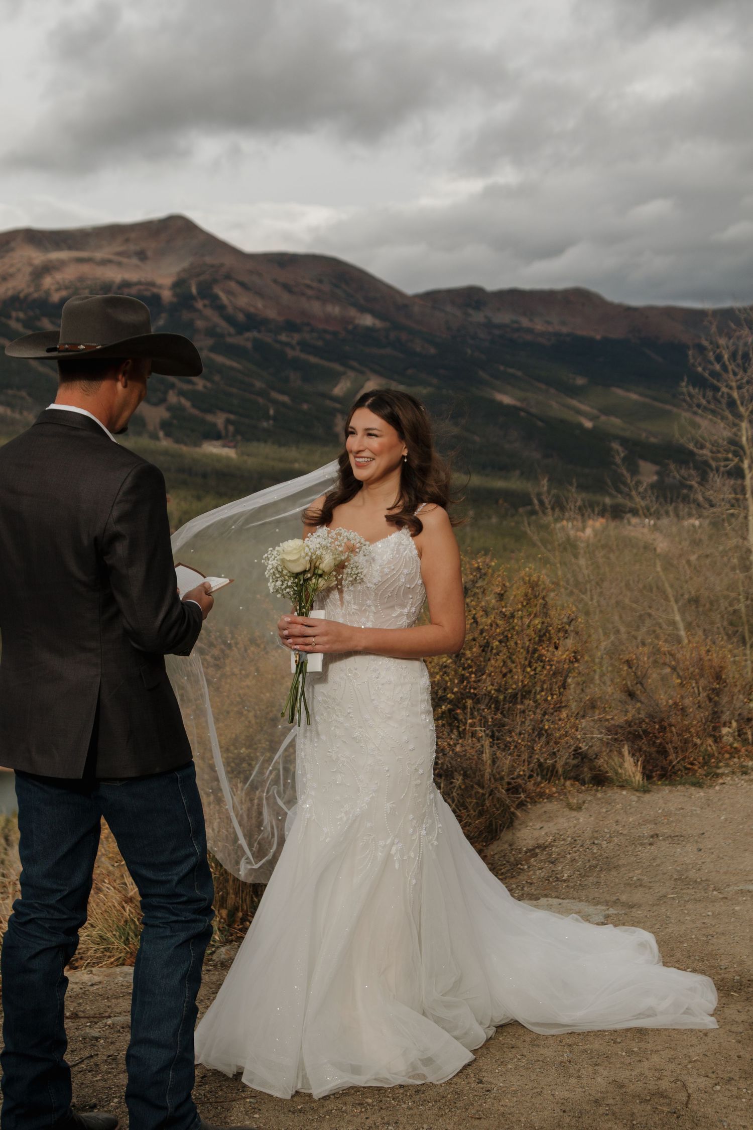 A mountain wedding ceremony with dramatic cloudy peaks in the background.