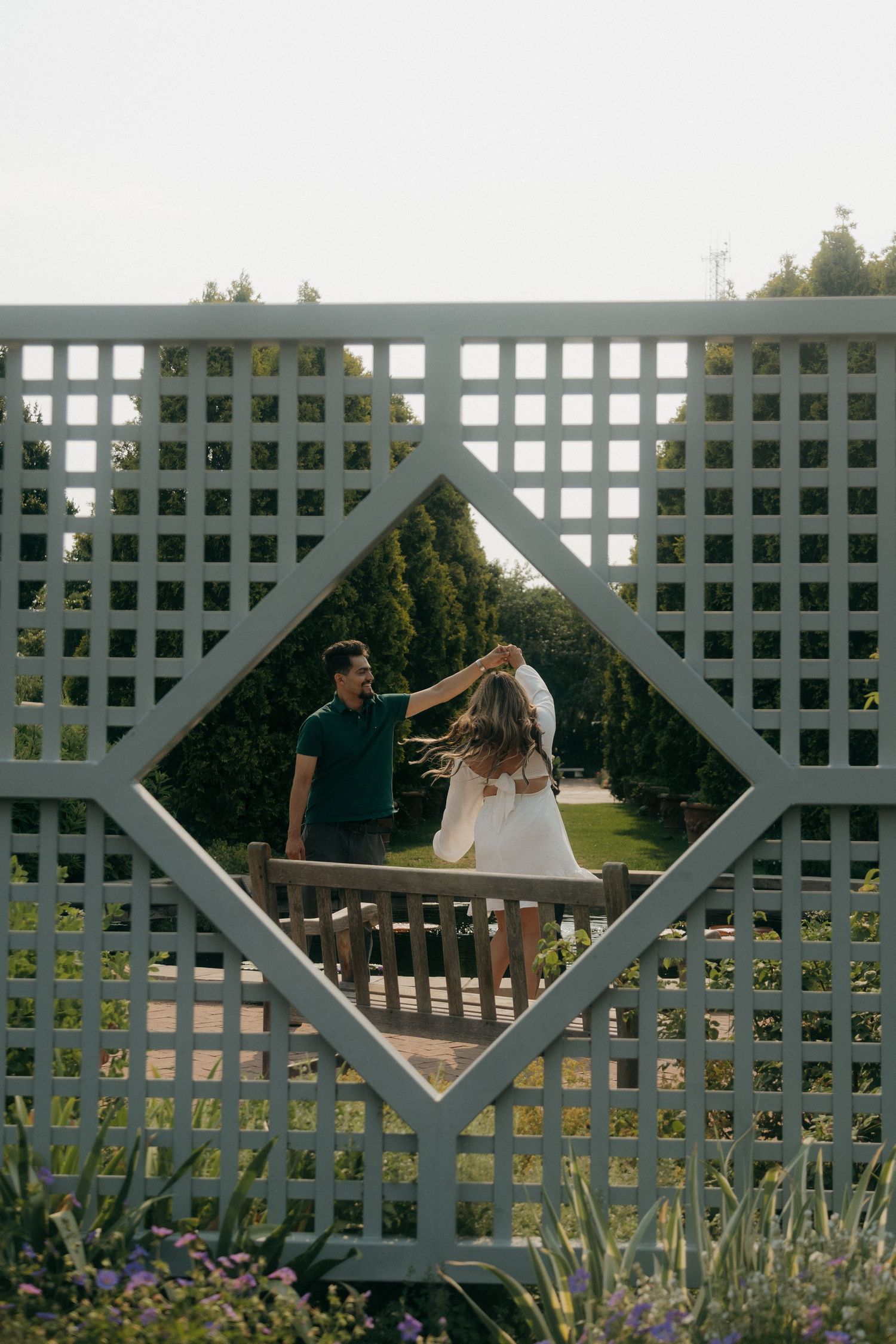 Couple dancing viewed through a diamond-shaped lattice garden wall frame.