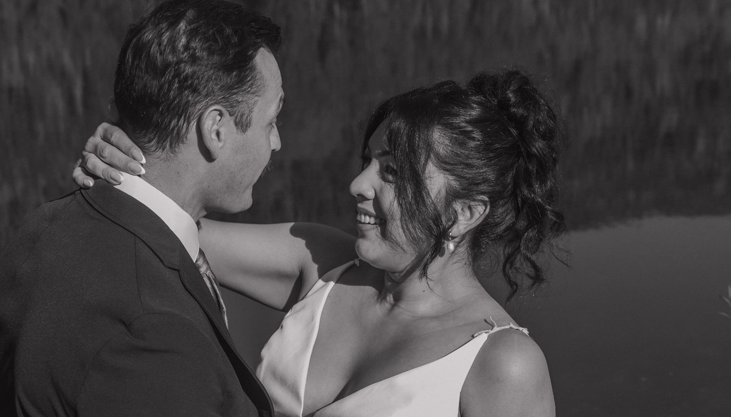 A black and white wedding portrait showing an intimate moment between the newlyweds.