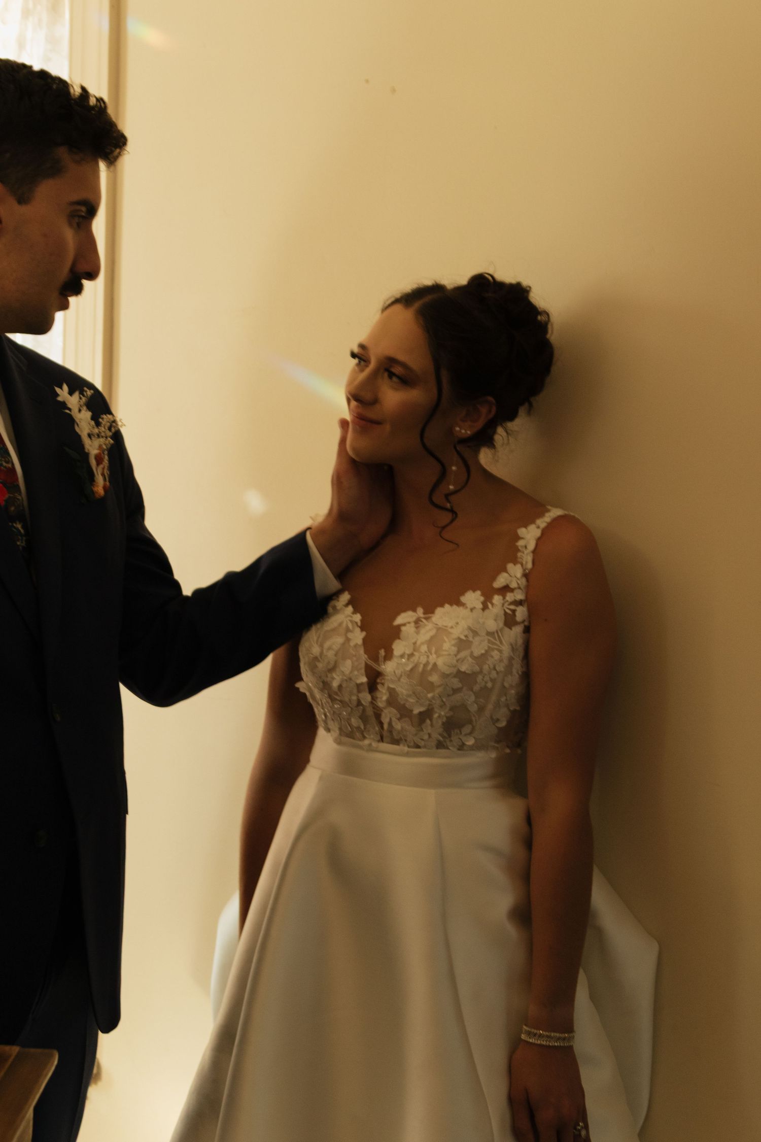 Intimate wedding moment captured in warm indoor lighting.