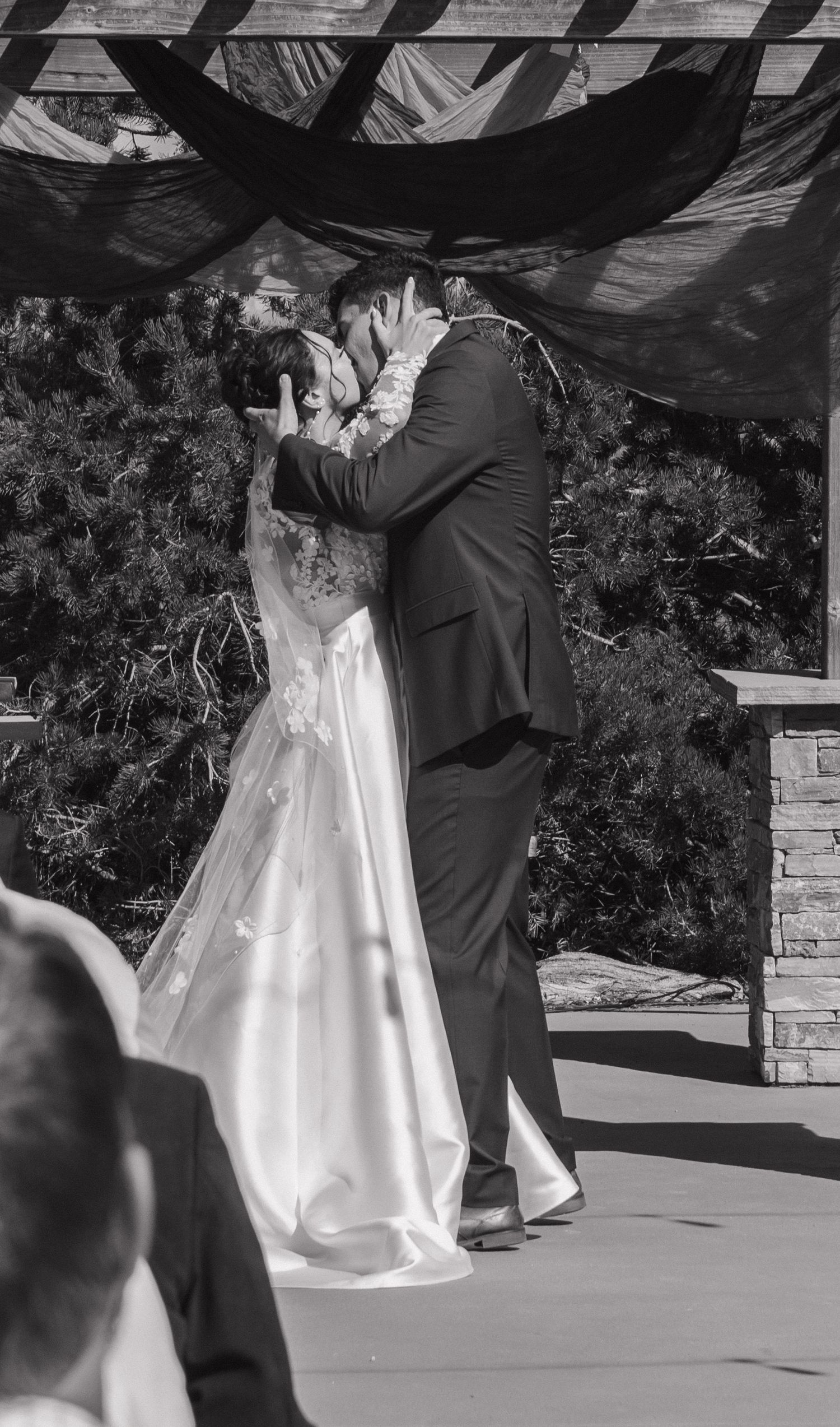 Black and white photo of a wedding ceremony under a draped canopy.