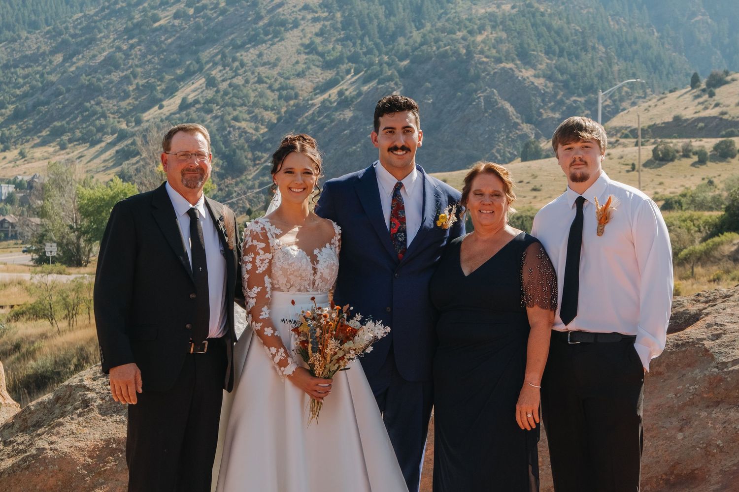 Wedding party poses together on mountainous terrain with scenic views.